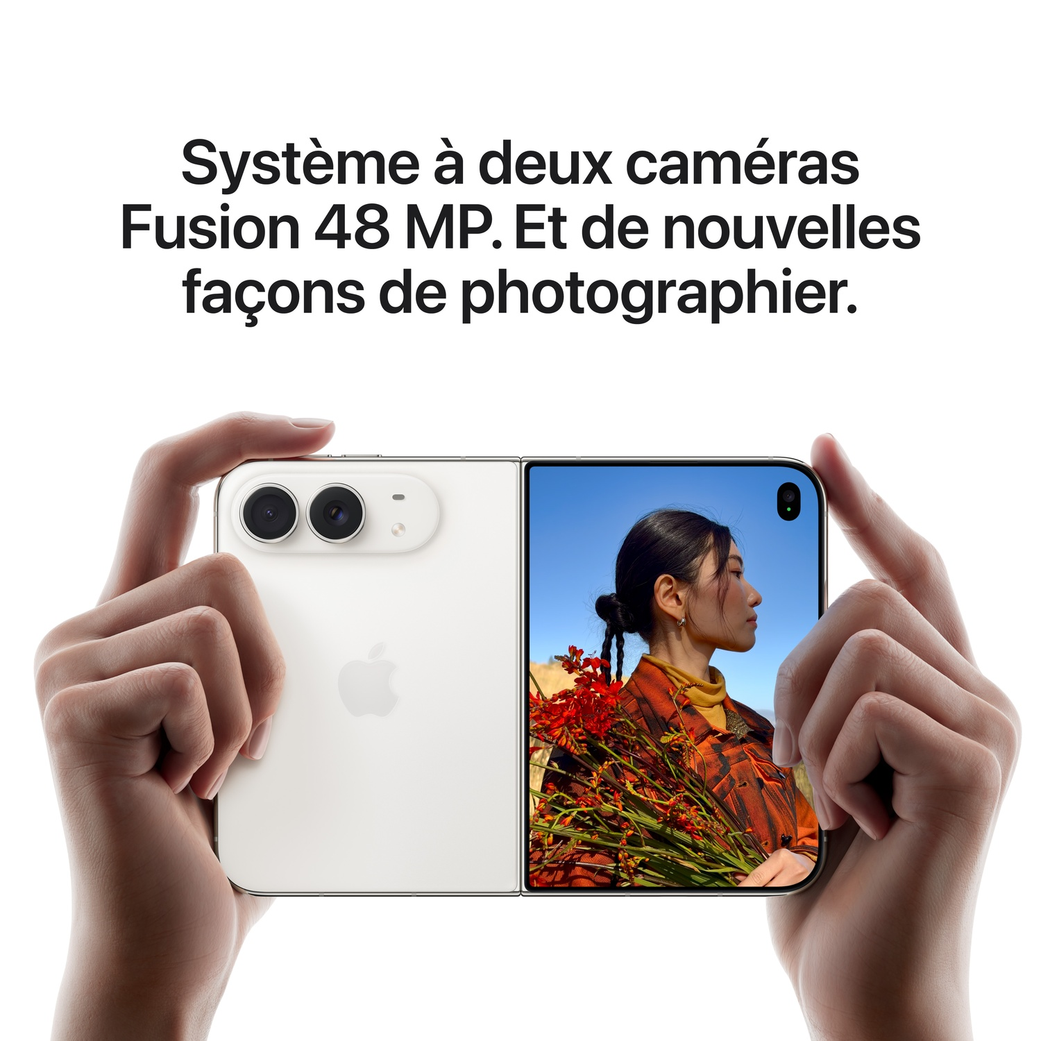 Des mains tiennent un smartphone pliable blanc avec double caméra sur fond blanc avec du texte.