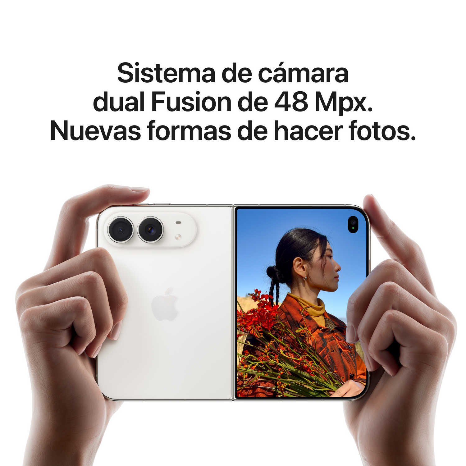 Manos sosteniendo un teléfono plegable blanco con cámara dual y pantalla.