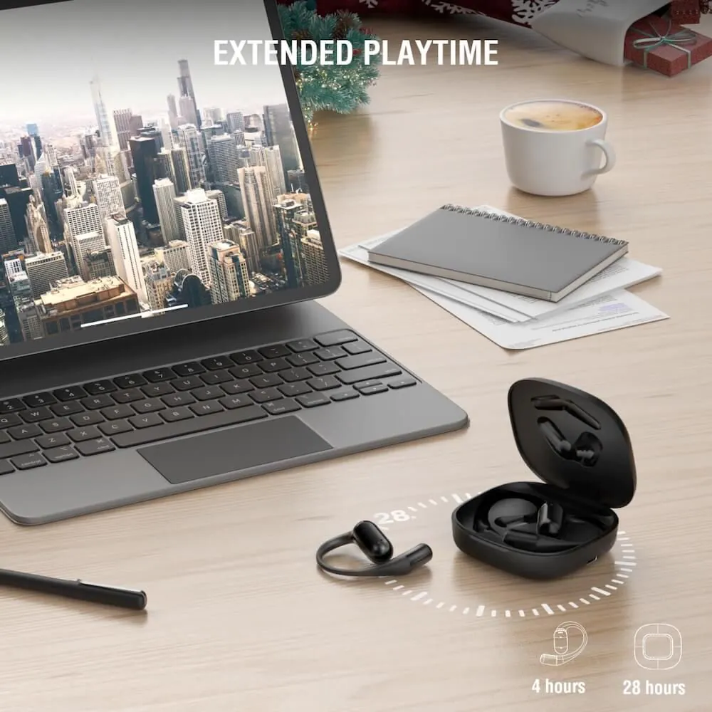 Ein Tablet mit Skyline-Hintergrundbild, Notizbuch, Kaffeetasse und kabellosen Ohrhörern in Ladebox auf einem Schreibtisch.