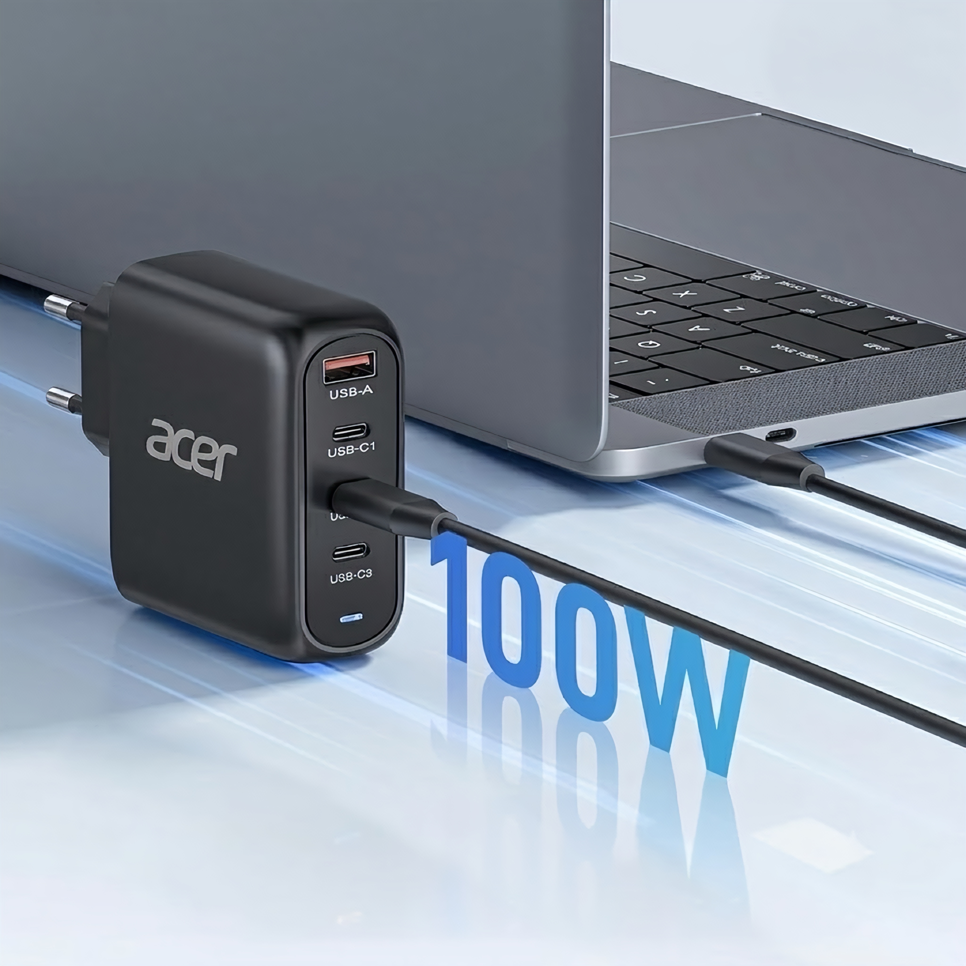 Un cargador USB negro Acer de 100W conectado, cargando una computadora portátil sobre una superficie azul.