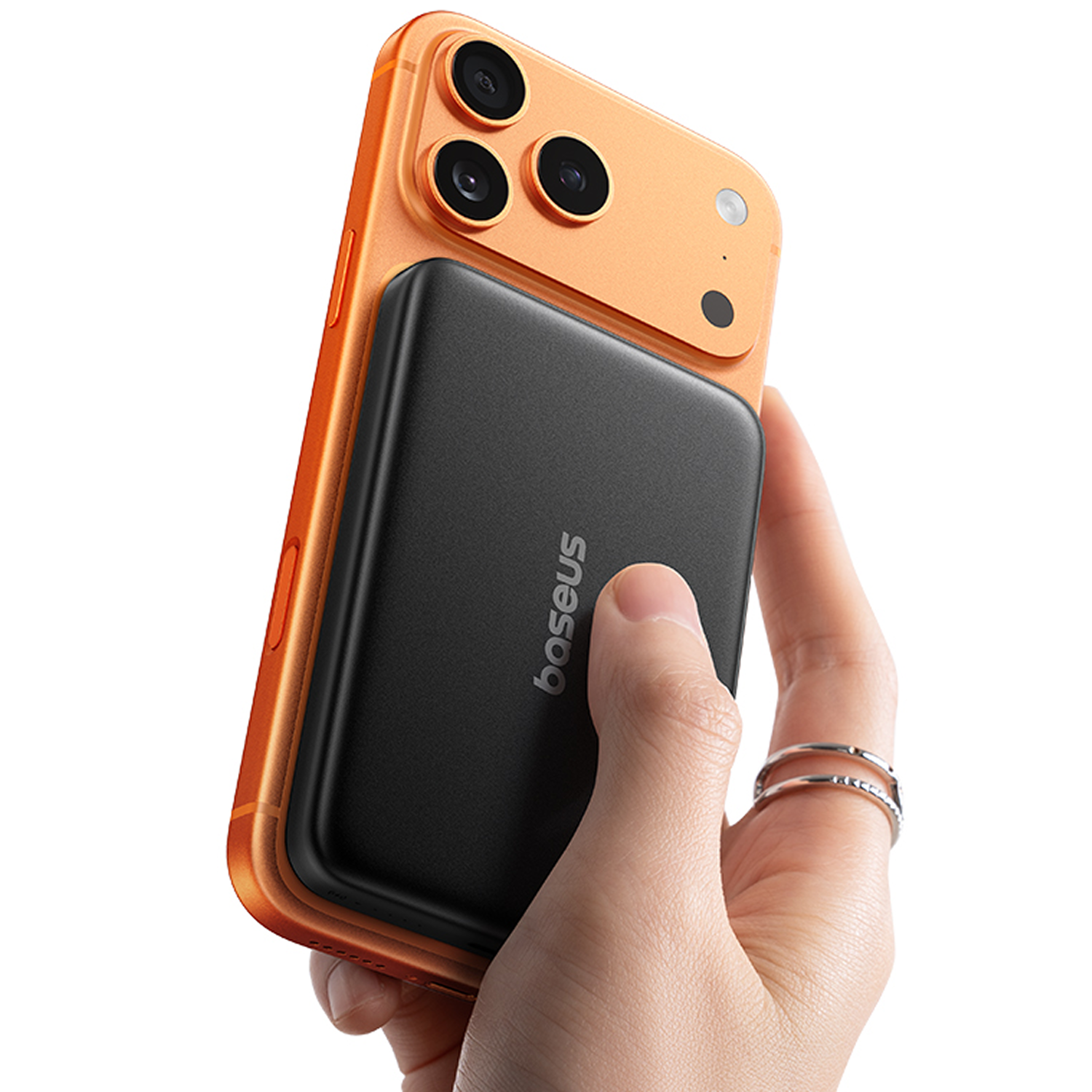 Una mano sostiene un smartphone naranja con una batería externa negra en la parte trasera.