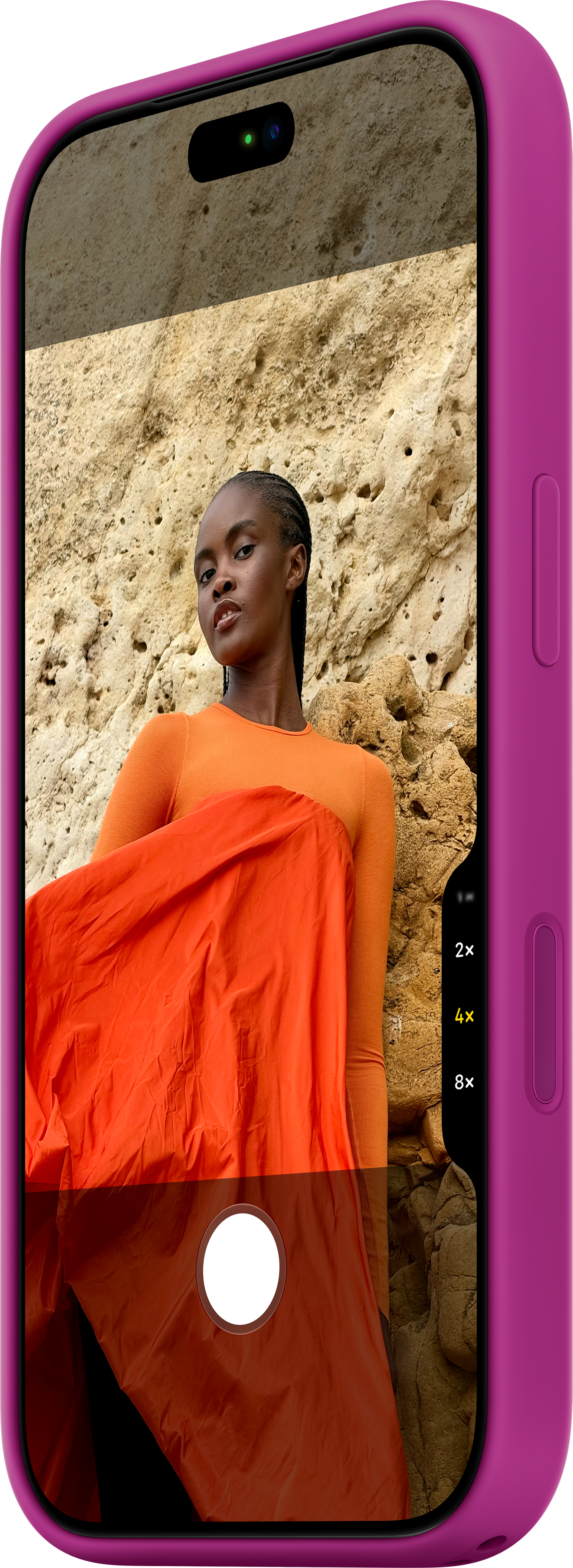 Un smartphone dans une coque rose affiche la photo d'une femme en haut orange sur fond rocheux.