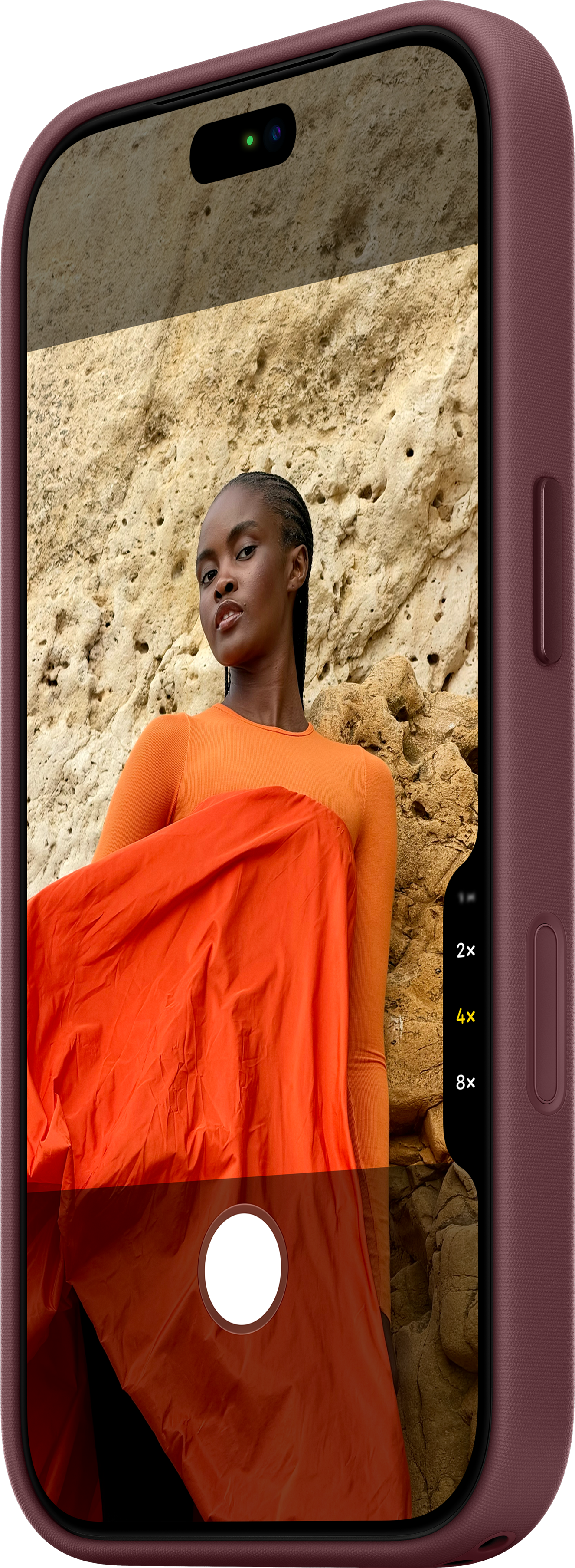 Écran de smartphone montrant une femme en orange devant une paroi rocheuse.
