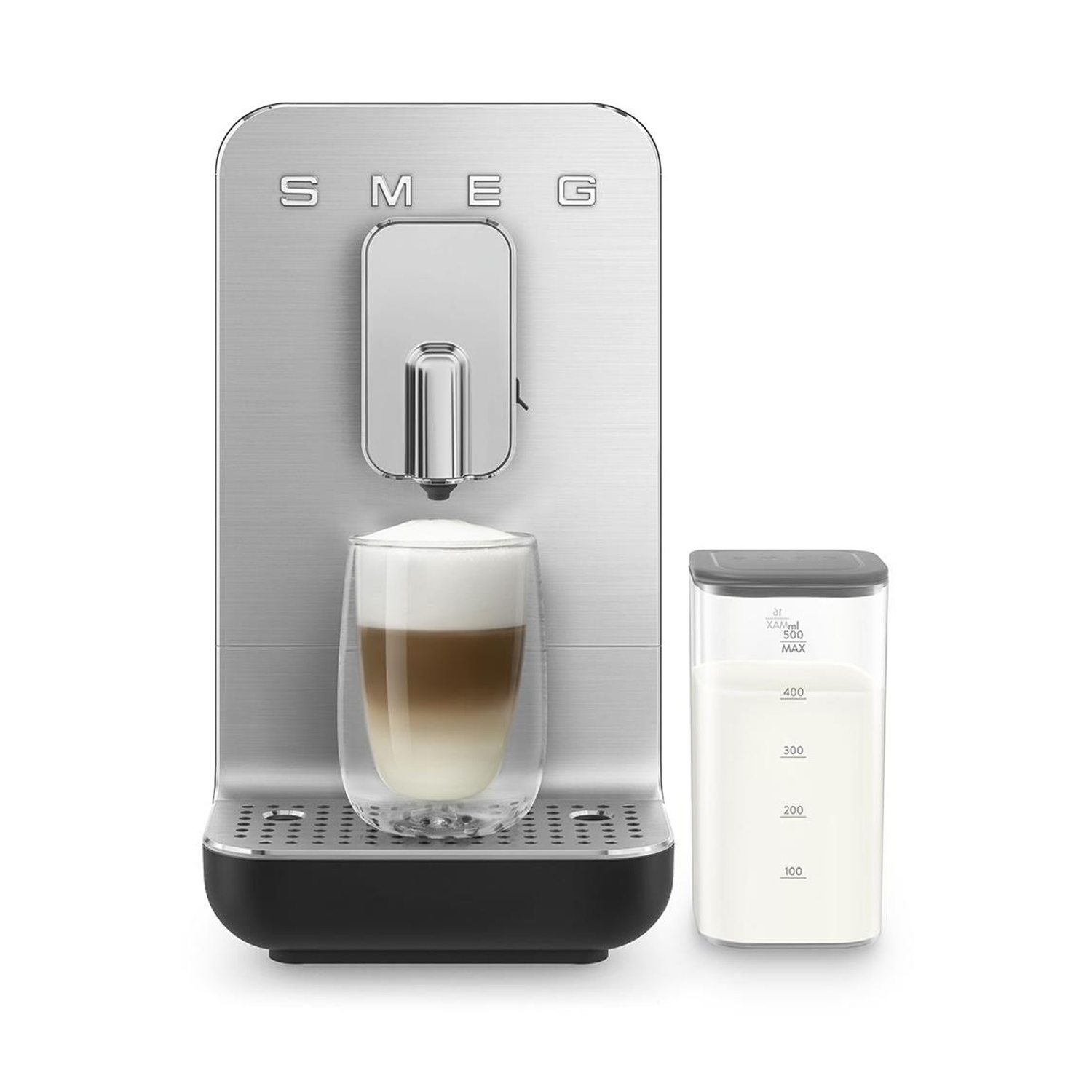 Una macchina da caffè Smeg argentata con un latte macchiato in un bicchiere e un contenitore del latte accanto su sfondo bianco.