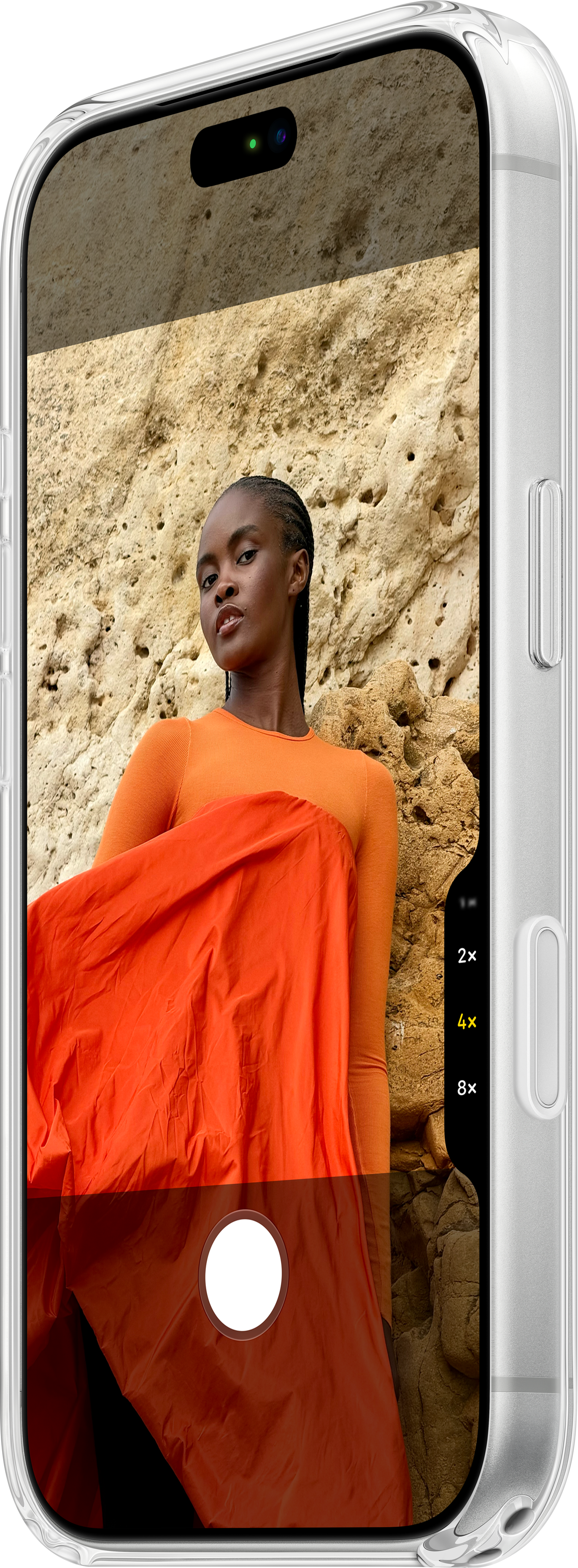 Un smartphone affiche une femme en orange devant un mur de roche.