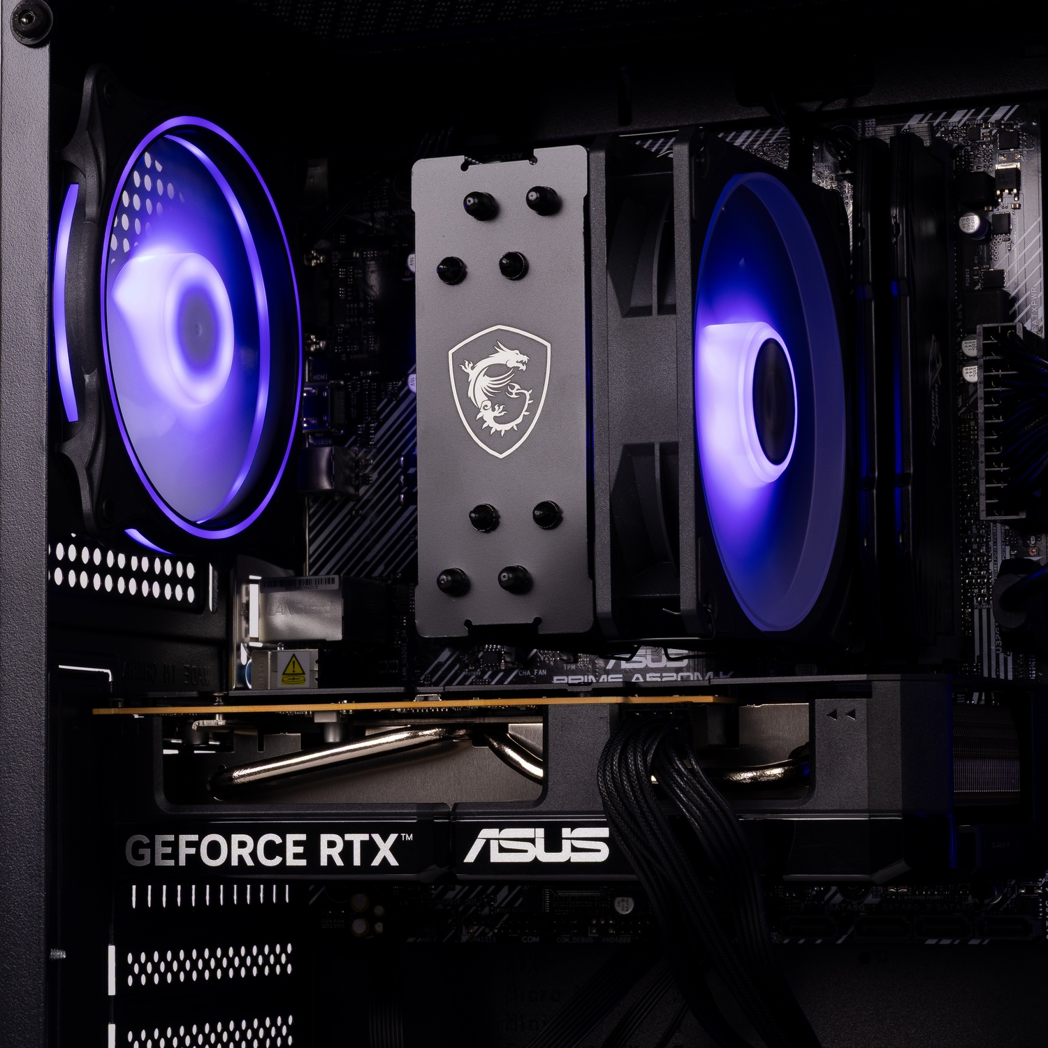 Intérieur de PC avec ventilateurs à LED violettes, un radiateur MSI et une carte graphique ASUS GeForce RTX.