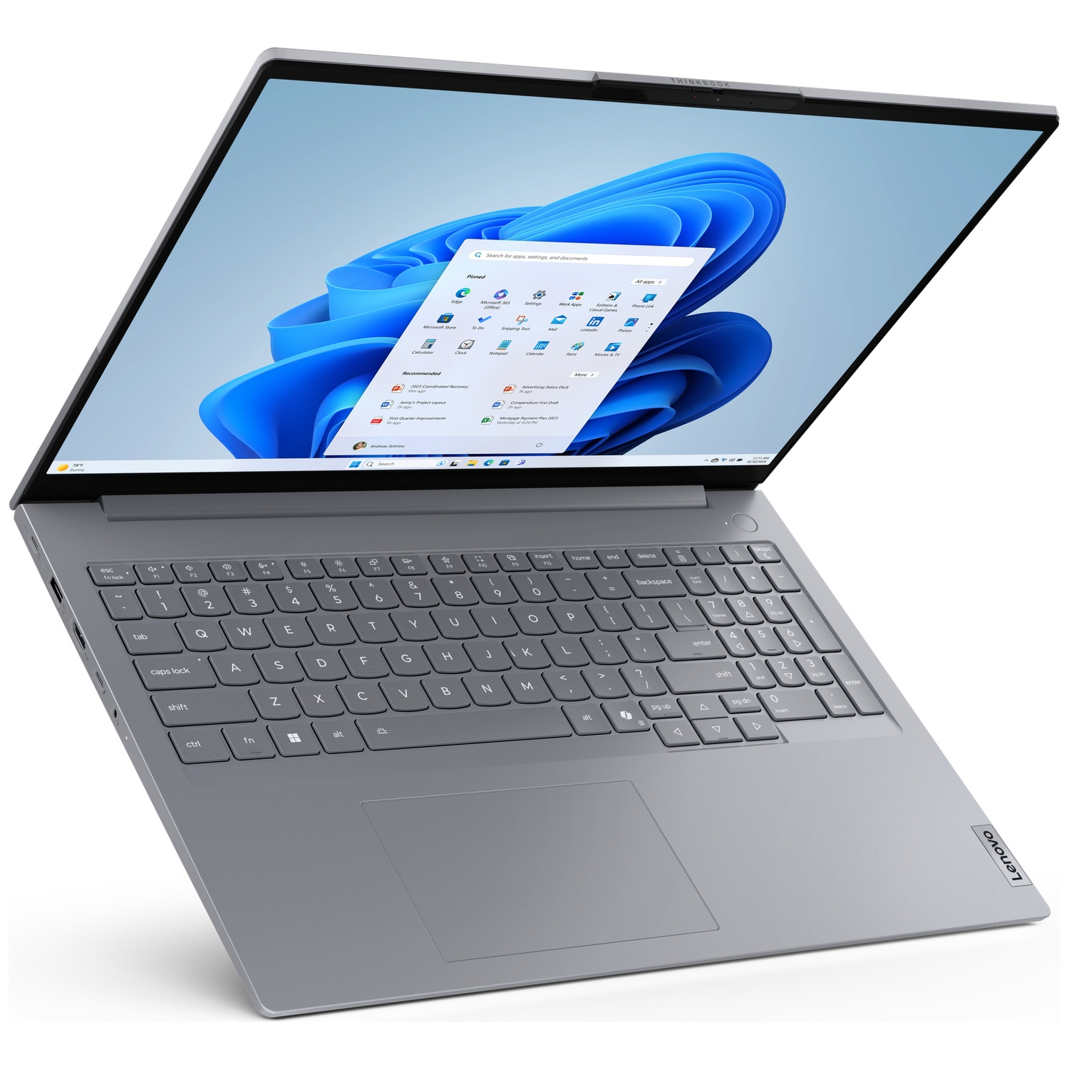 Een zilveren Lenovo ThinkBook-laptop toont het Windows 11-bureaublad met een blauwe golfachtergrond.
