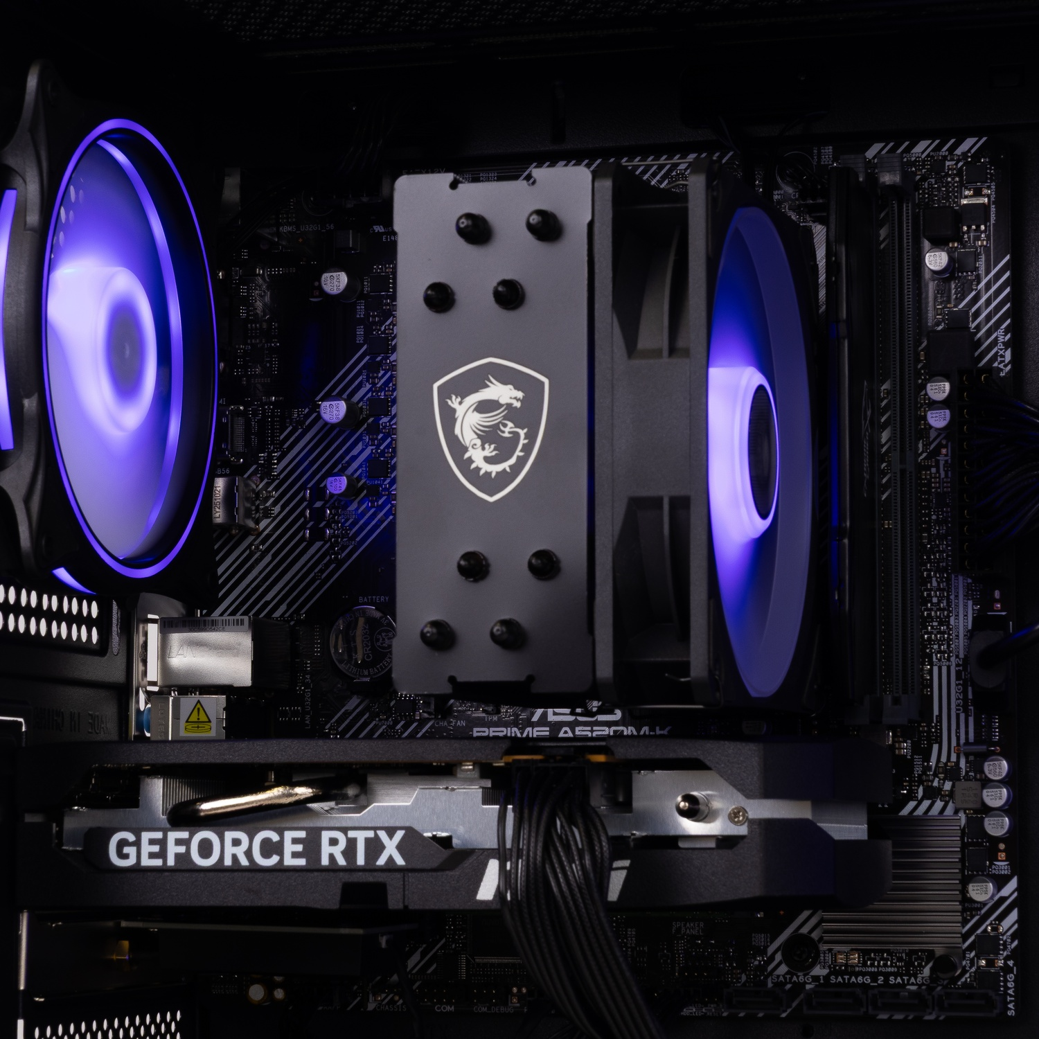 Intérieur de PC avec refroidisseur MSI, ventilateurs à LED bleue et carte graphique GeForce RTX sur la carte mère.