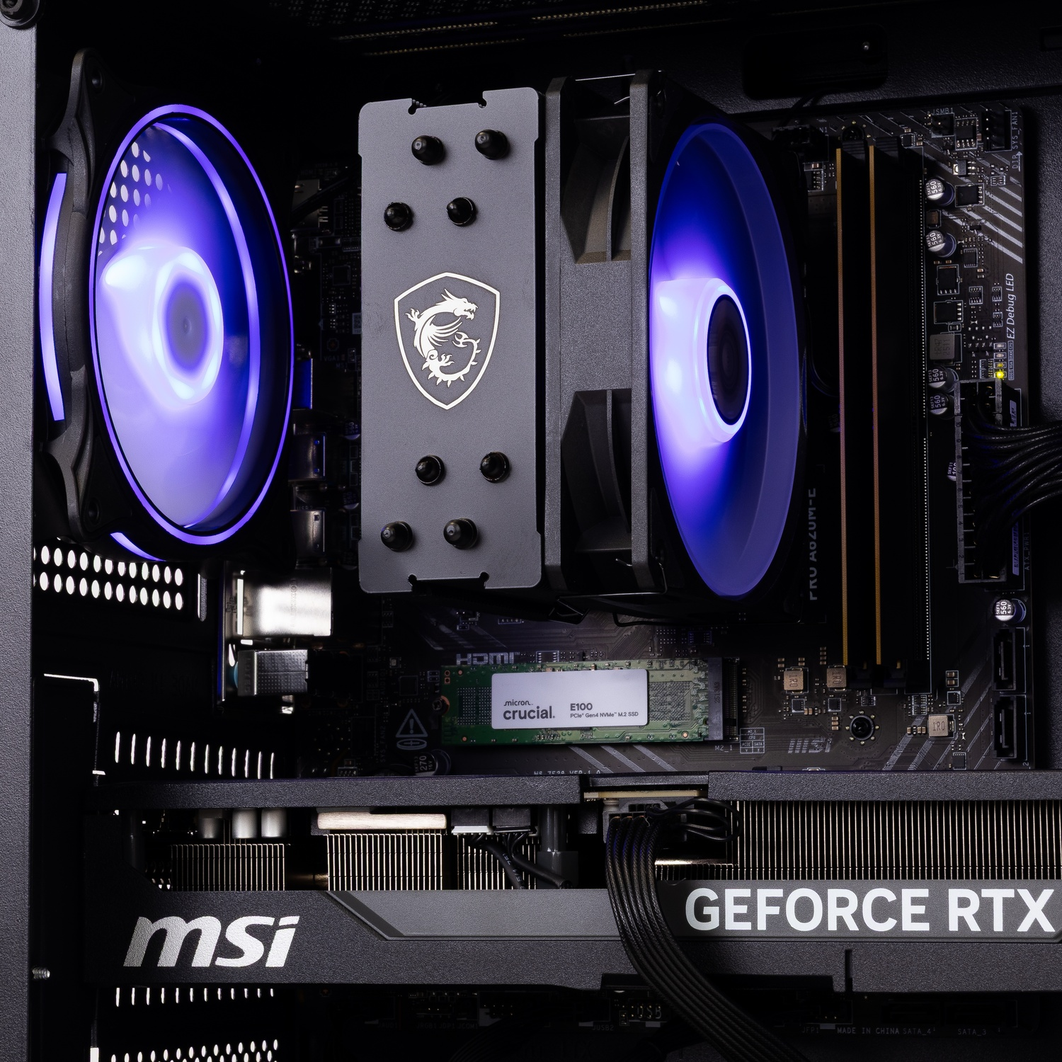 PC-interieur met oplichtende blauwe ventilatoren, MSI-koeler, GeForce RTX-grafische kaart en Crucial SSD op moederbord.