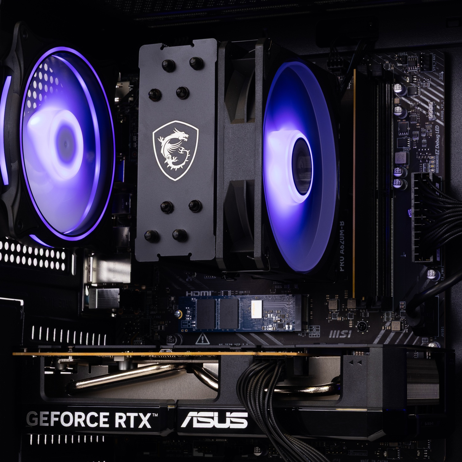 PC-interieur met MSI CPU-koeler, twee paarse verlichte ventilatoren, M.2 SSD en ASUS GeForce RTX videokaart.