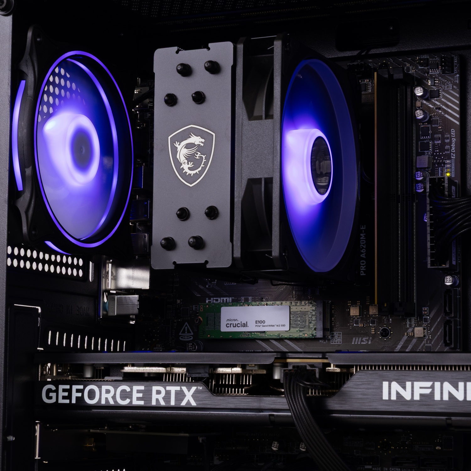 Intérieur d'un PC avec carte mère, ventilateurs bleus, refroidisseur de processeur, SSD Crucial et carte graphique.