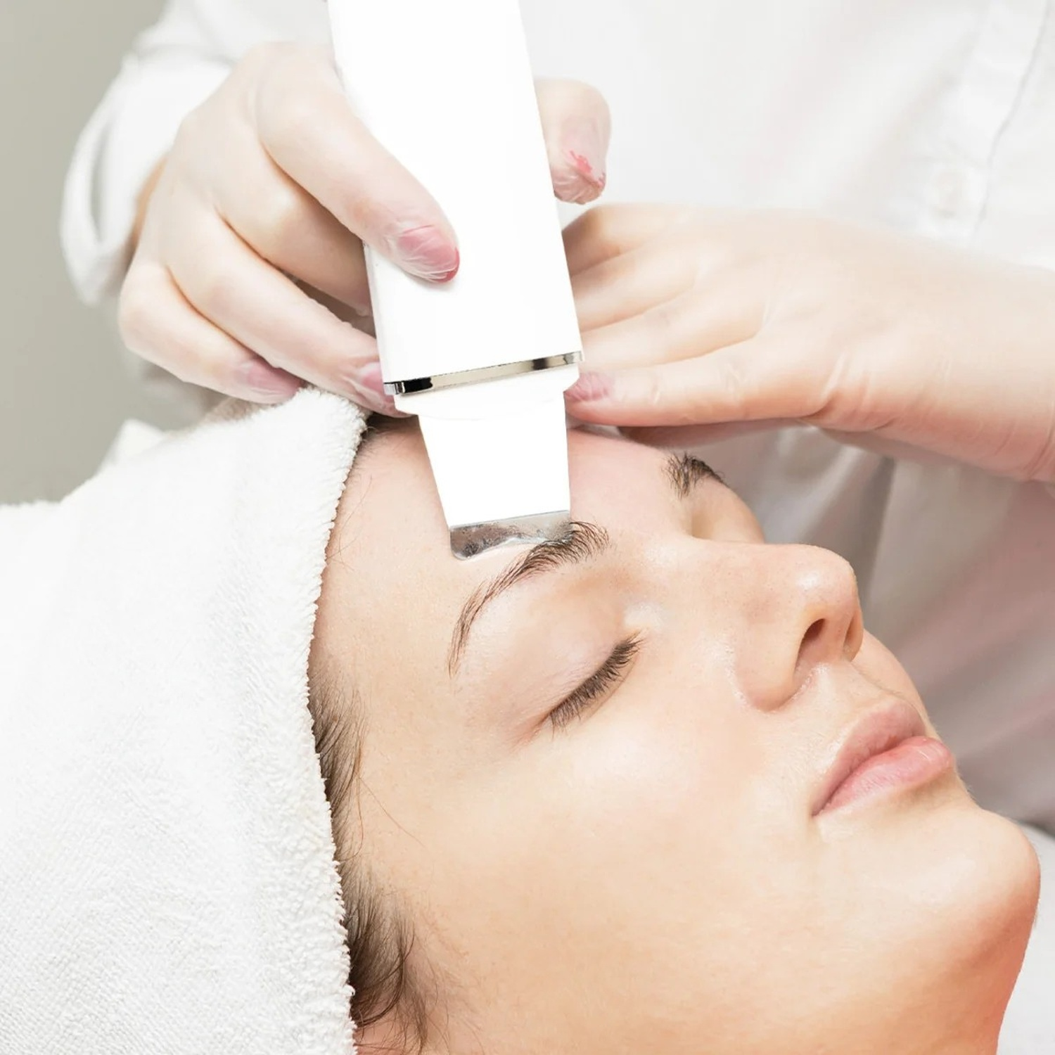 Una donna riceve un trattamento viso ad ultrasuoni con un dispositivo a spatola.