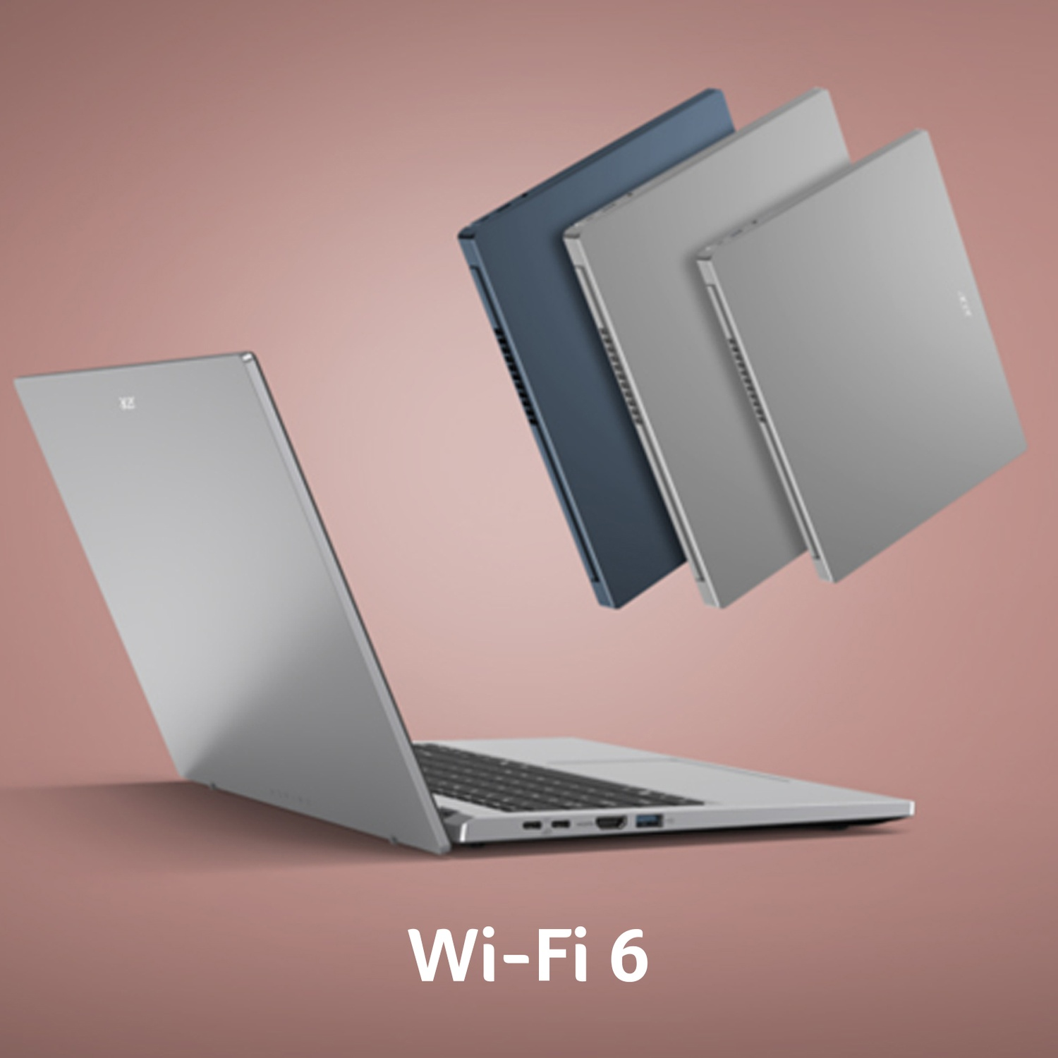 Quattro laptop in argento e blu fluttuano su uno sfondo rosa con la scritta Wi-Fi 6.
