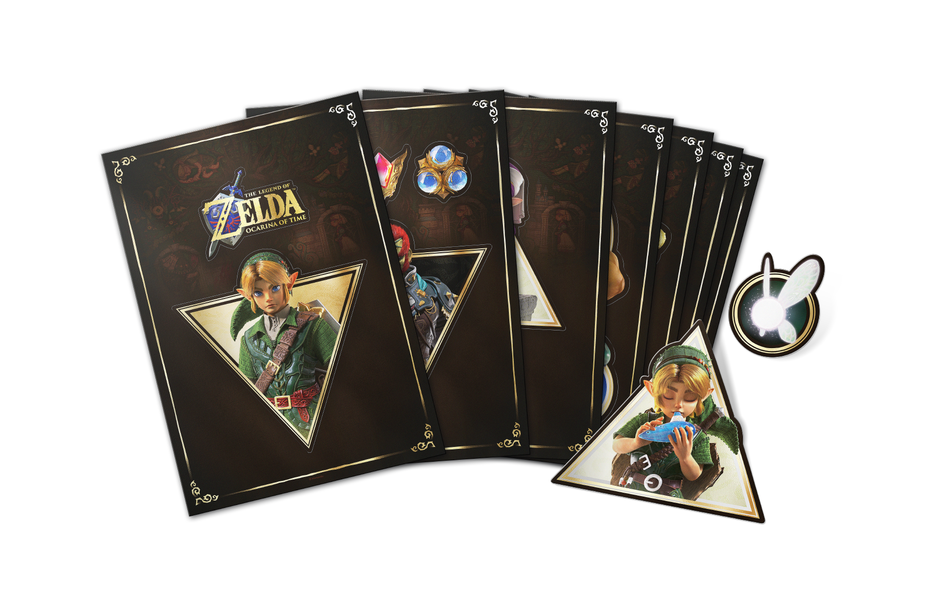Przedmioty z The Legend of Zelda Ocarina of Time, w tym artbooki i świecąca naklejka z wróżką.