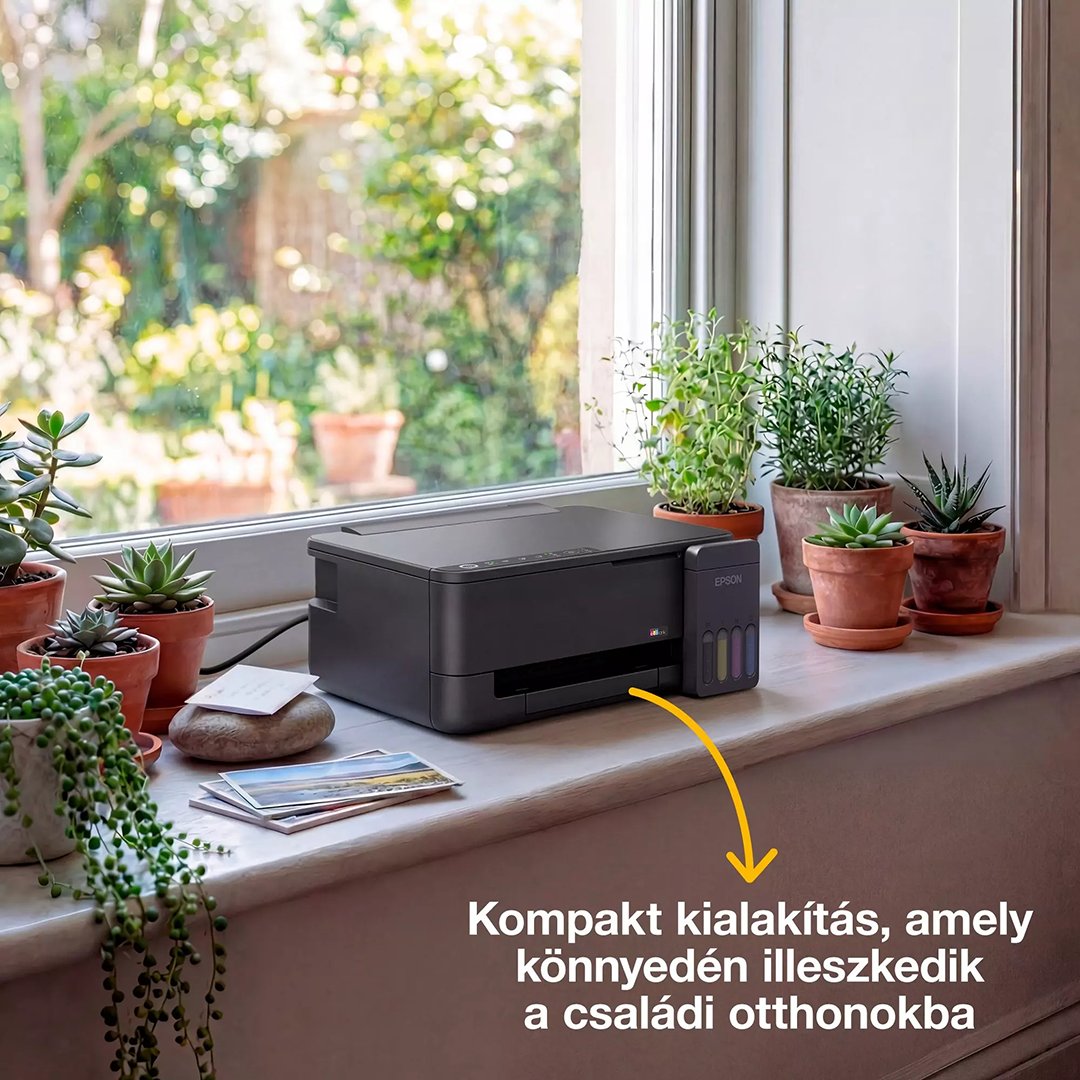 Egy fekete Epson nyomtató áll a napos ablakpárkányon cserépbe ültetett növények és fényképek között, kertre néző kilátással.