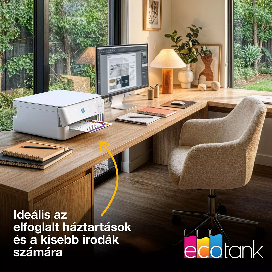 Egy fehér nyomtató áll egy faíróasztalon egy világos irodában monitorral, lámpával és székkel.