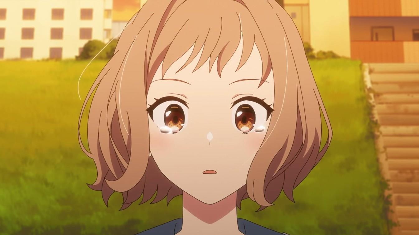 Nahaufnahme eines weinenden Anime-Mädchens mit kurzem braunen Haar und großen Augen im Freien.