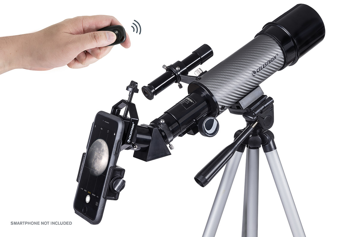Tripod üstünde akıllı telefon tutuculu ve elinde uzaktan kumanda olan bir Celestron teleskop.