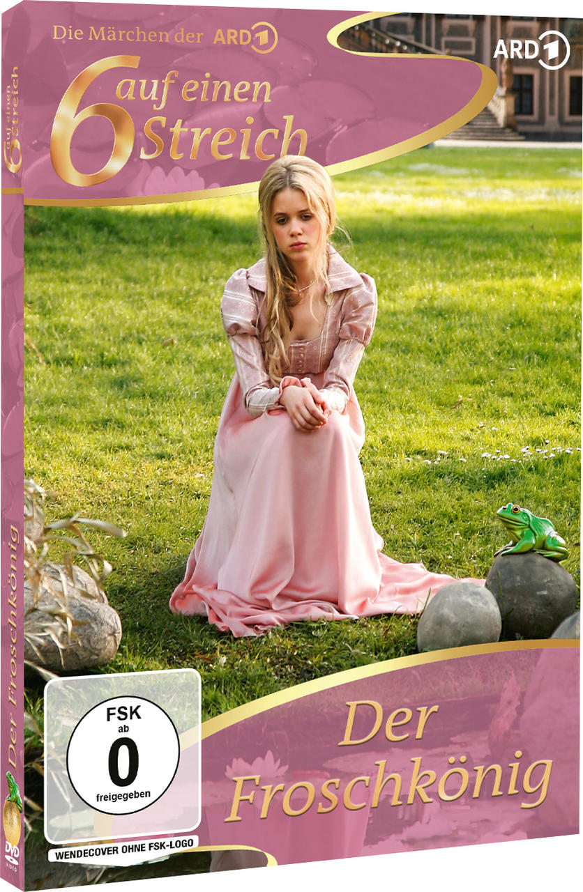 Eine blonde Frau im rosa Kleid sitzt im Gras vor einer Wiese, ein Frosch sitzt auf einem Stein.