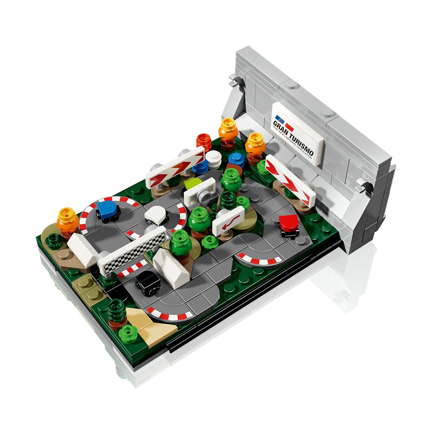 Un diorama di pista Lego Gran Turismo con auto in miniatura, alberi e segnali stradali.