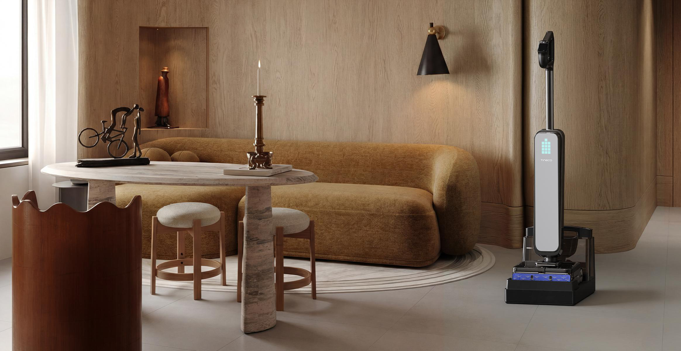 Ein schwarzer Staubsauger auf der Ladestation im modernen Holzwohnzimmer mit Tisch, gelbem Sofa und Kerze.