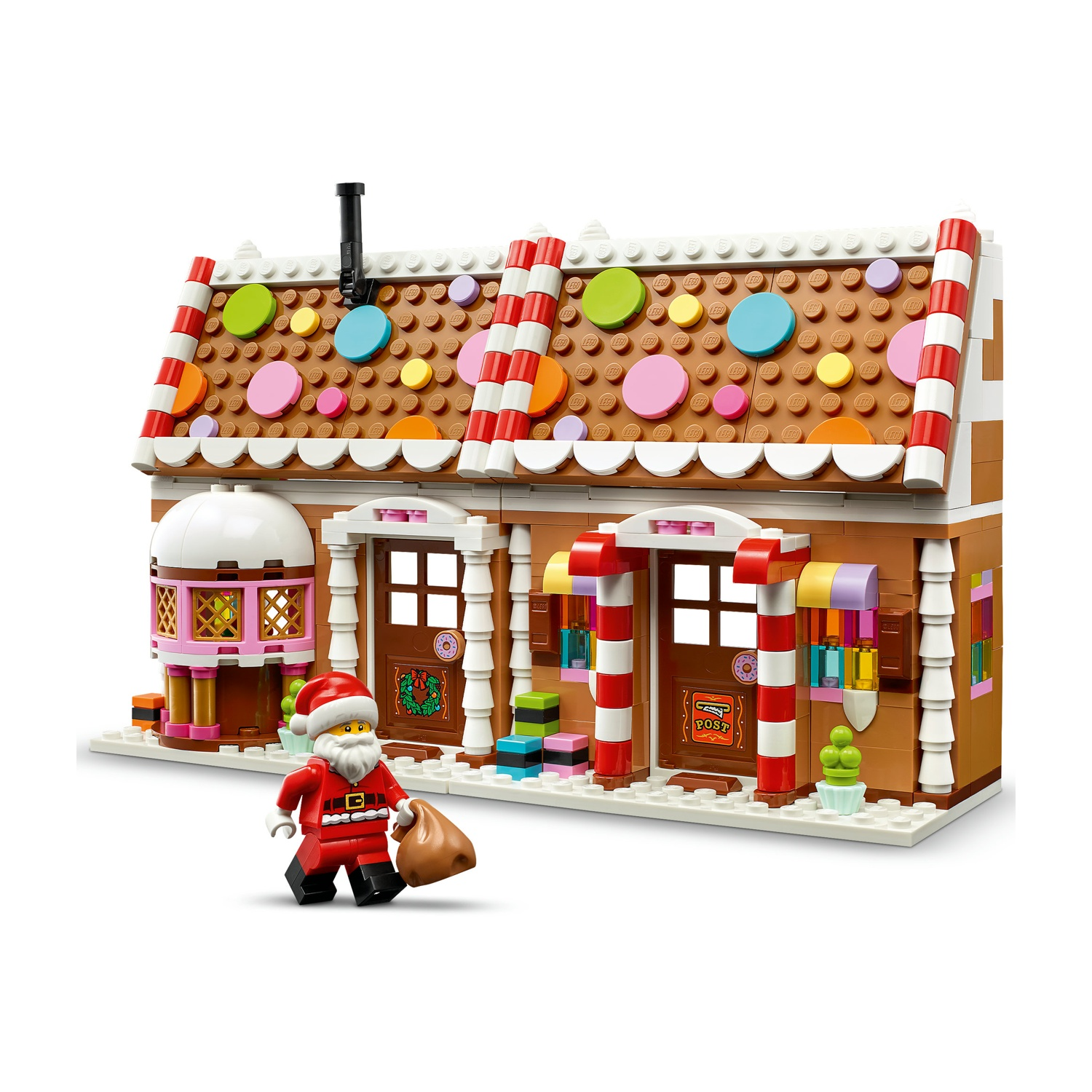 Casa di pan di zenzero Lego con decorazioni colorate, colonne di bastoncini di zucchero e Babbo Natale con sacco.