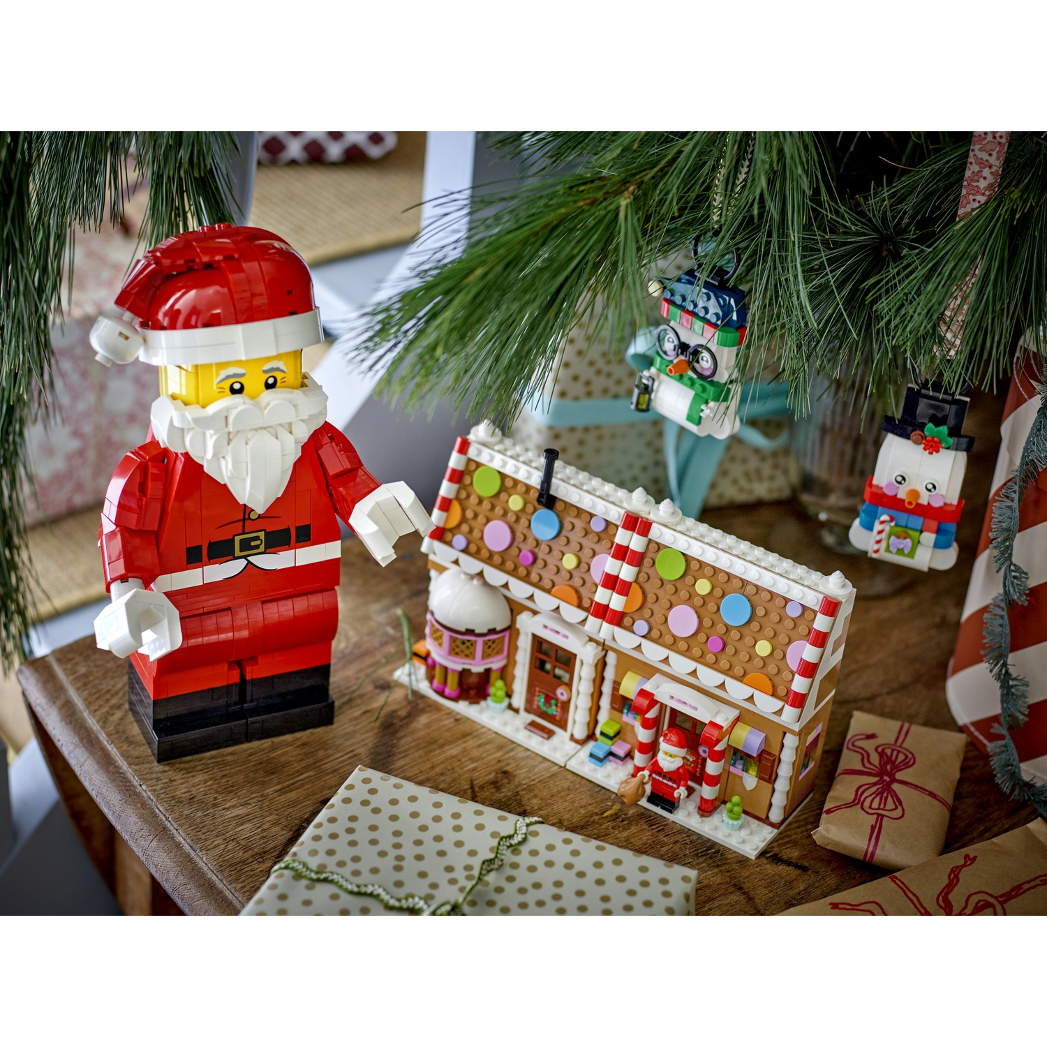 Una figura di Babbo Natale Lego si trova accanto a una casetta di pan di zenzero Lego.