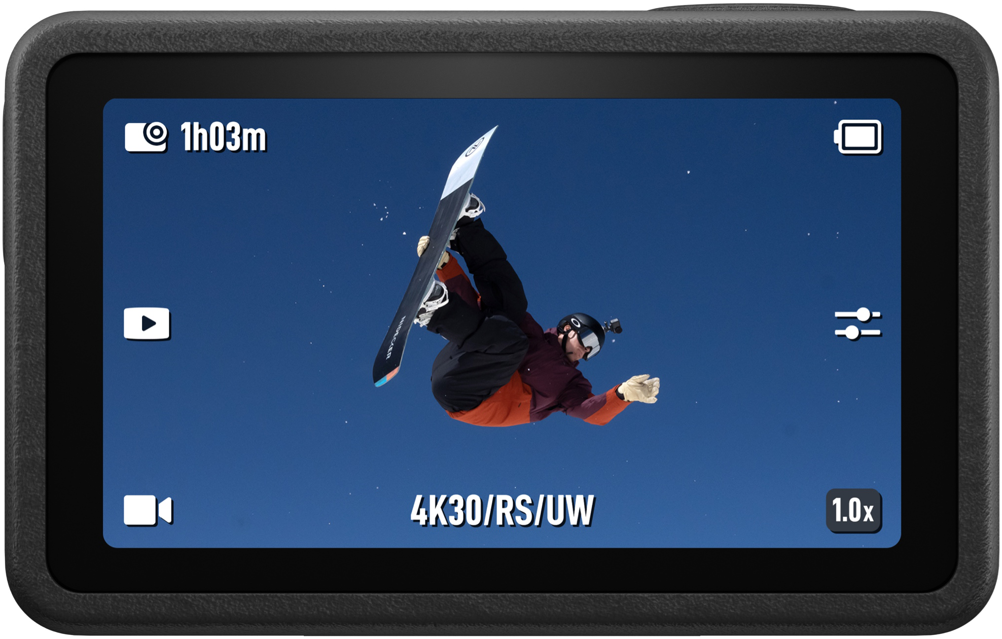 Egy akciókamera kijelzőjén egy kék égbolt előtt ugró snowboardos látható.