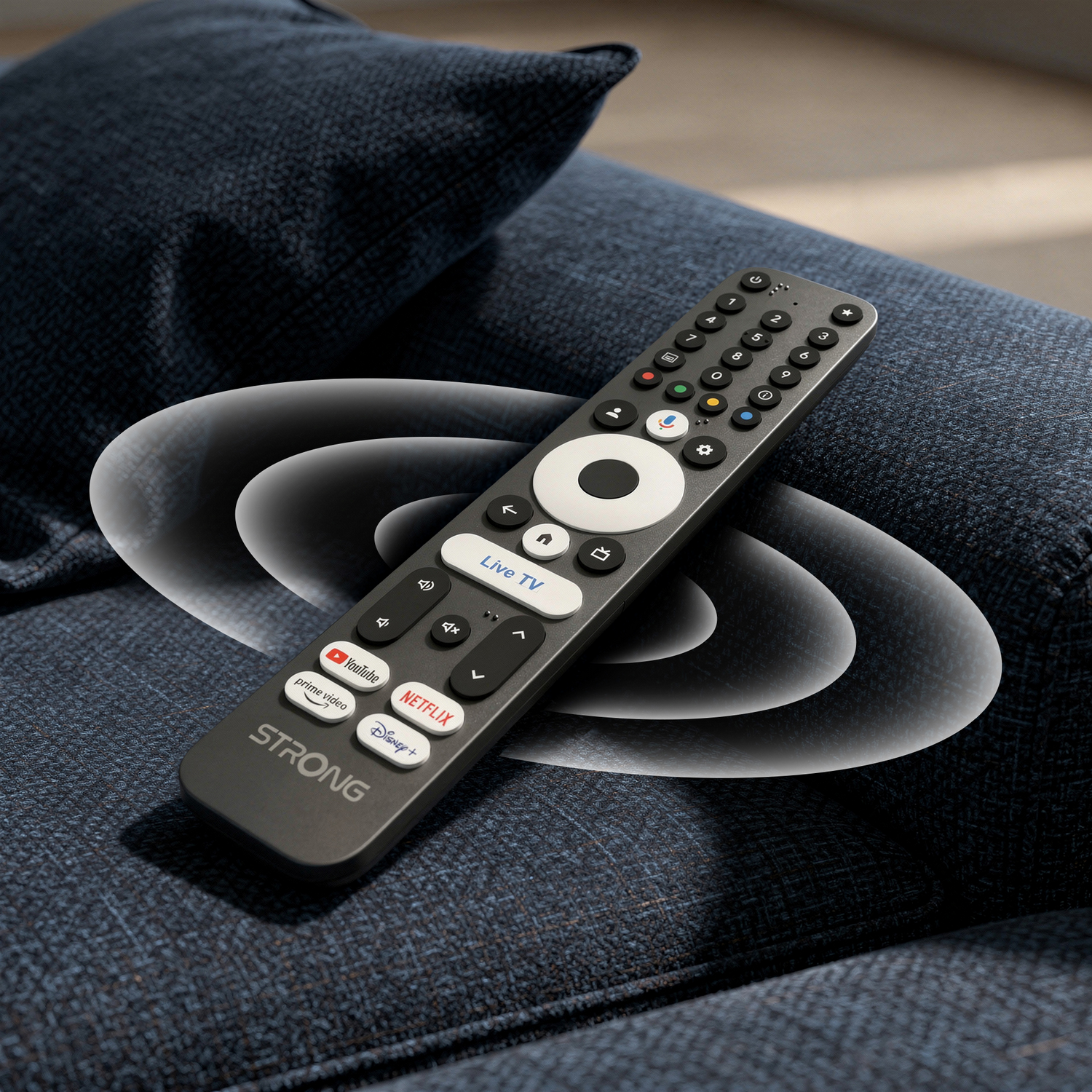 Un control remoto negro de STRONG descansa en un sofá azul con ondas de sonido.