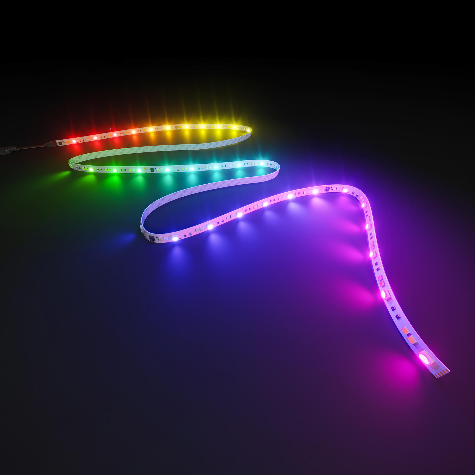 Eine flexible LED-Lichtleiste windet sich auf einer dunklen Oberfläche und leuchtet in bunten Farben.