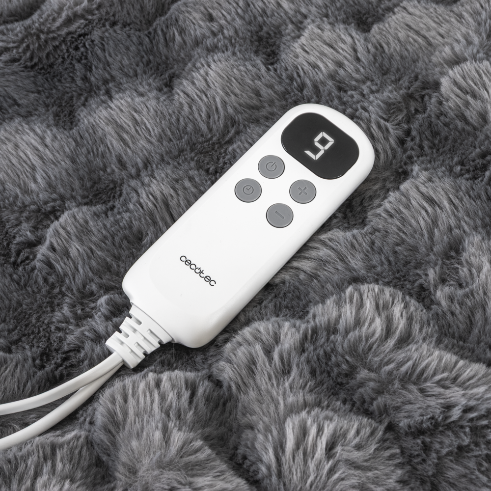 Un control remoto blanco con botones y pantalla descansa sobre una manta de felpa gris.