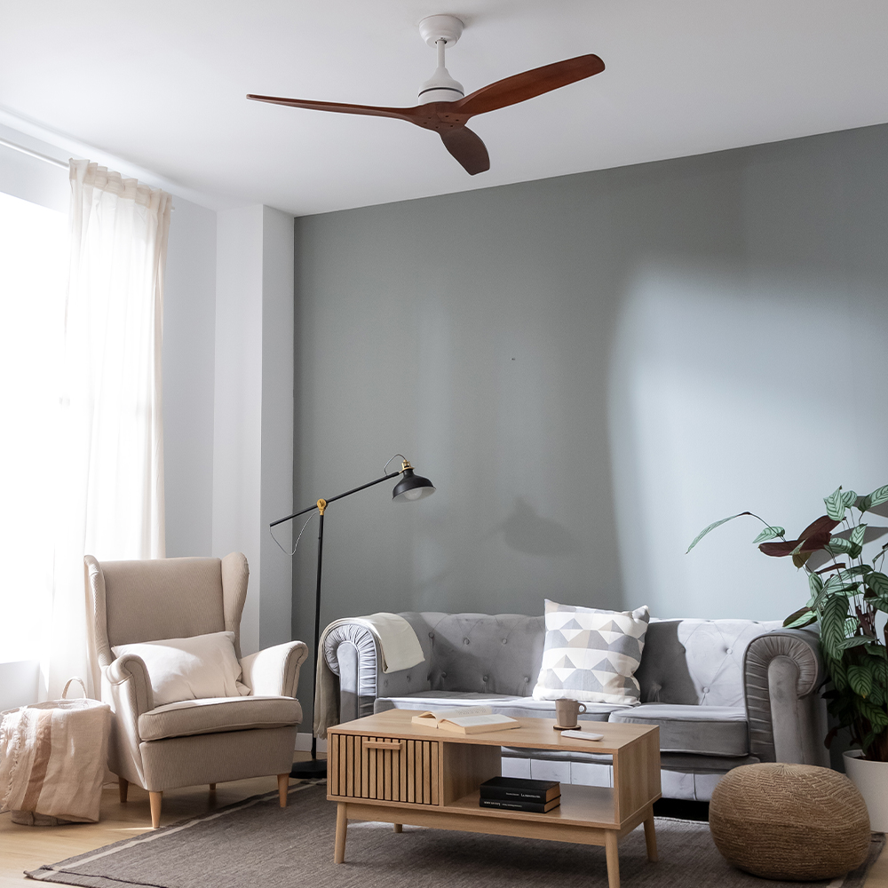 Sala de estar con sofá gris, sillón beige, mesa de centro de madera, lámpara y ventilador de techo.