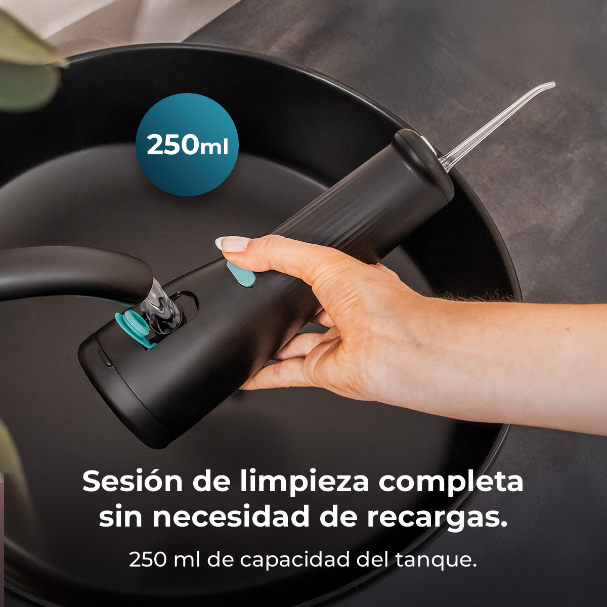 Una mano llenando un irrigador bucal negro en un lavabo, con texto de 250ml de capacidad.