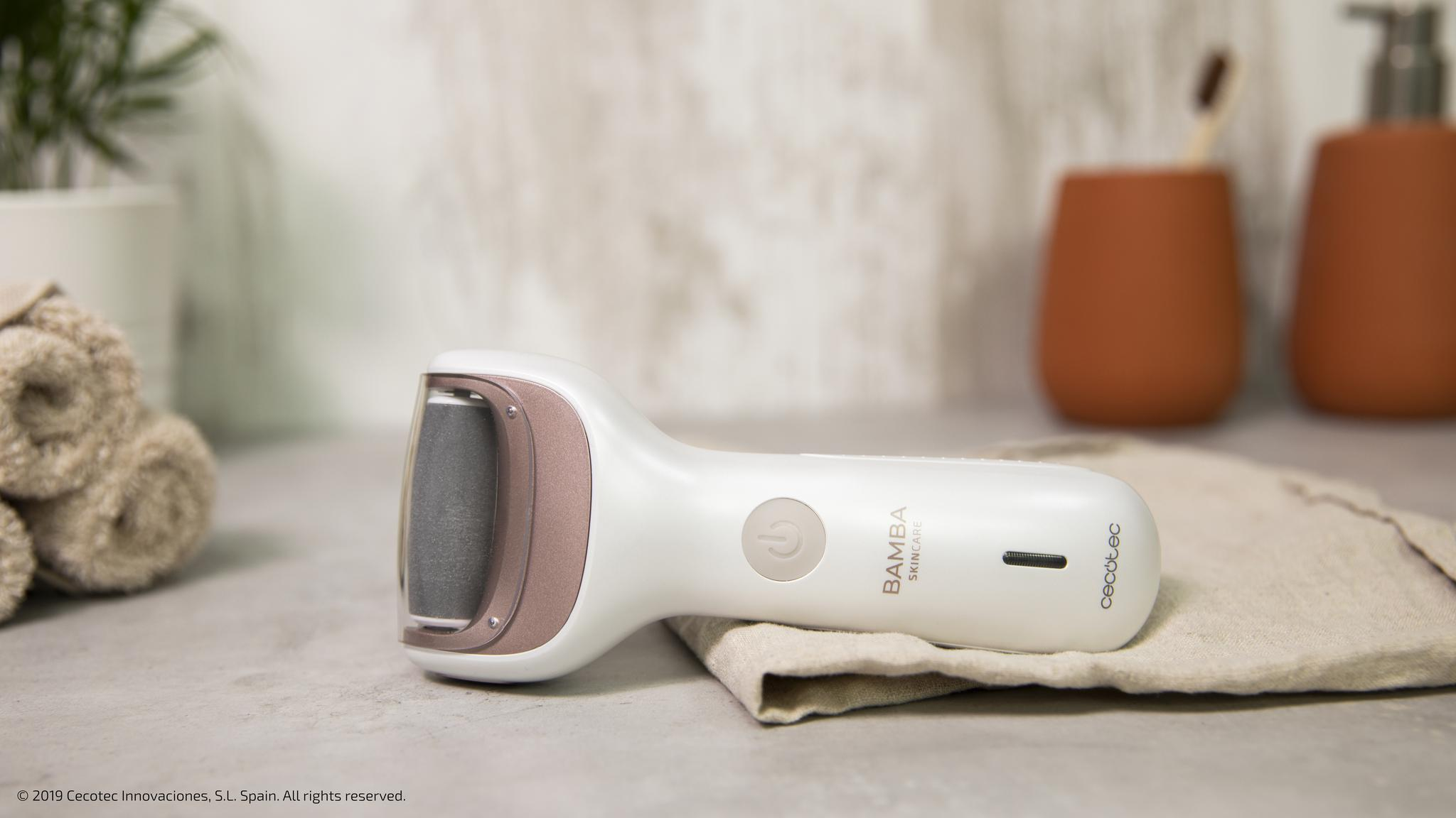 Una lima de pies blanca Bamba Skincare con un rodillo gris descansa sobre un paño en un baño.