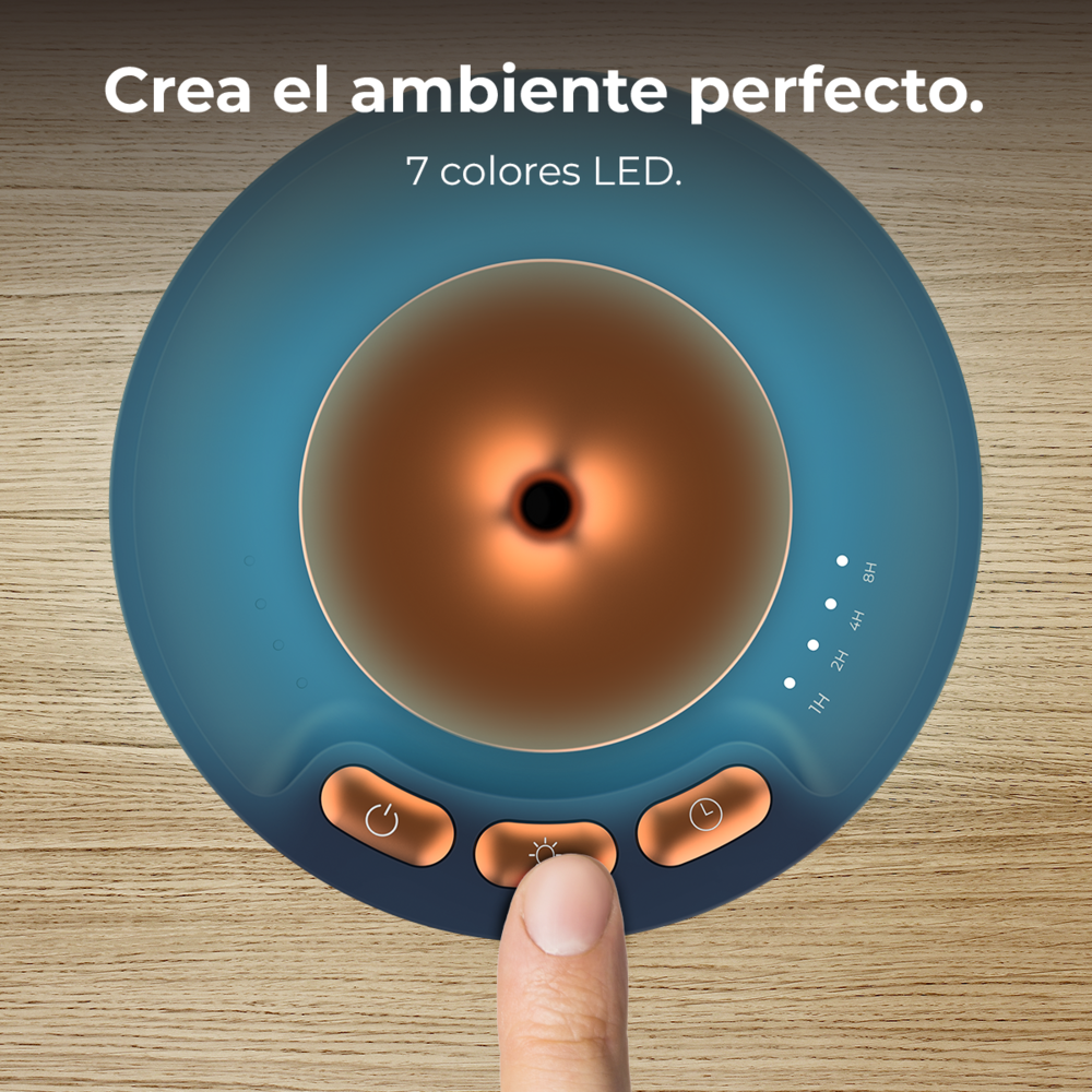 Un dedo presionando el botón de luz en un difusor azul y cobre sobre madera.