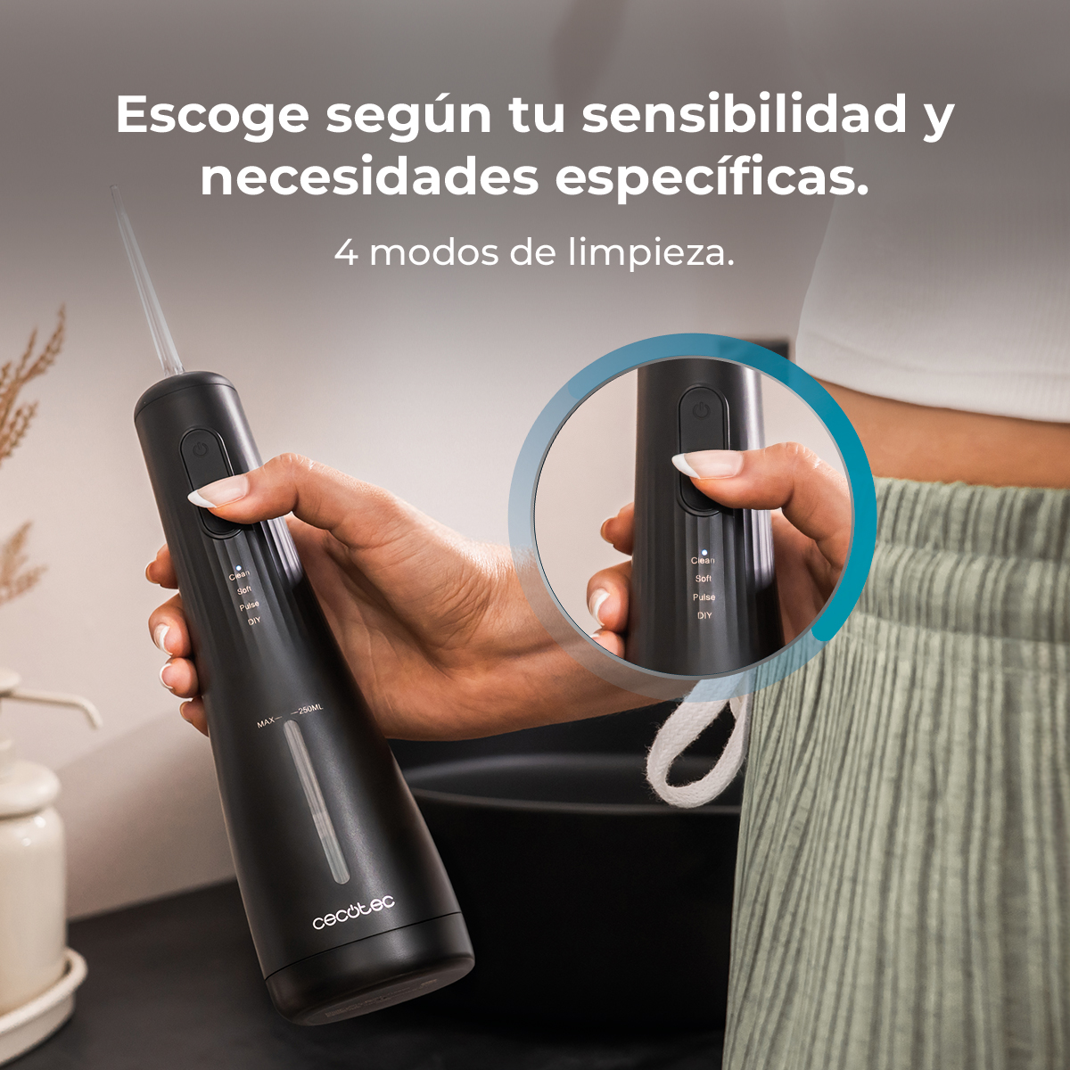 Mano sostiene un irrigador bucal inalámbrico negro con cuatro modos de limpieza, primer plano de los botones.