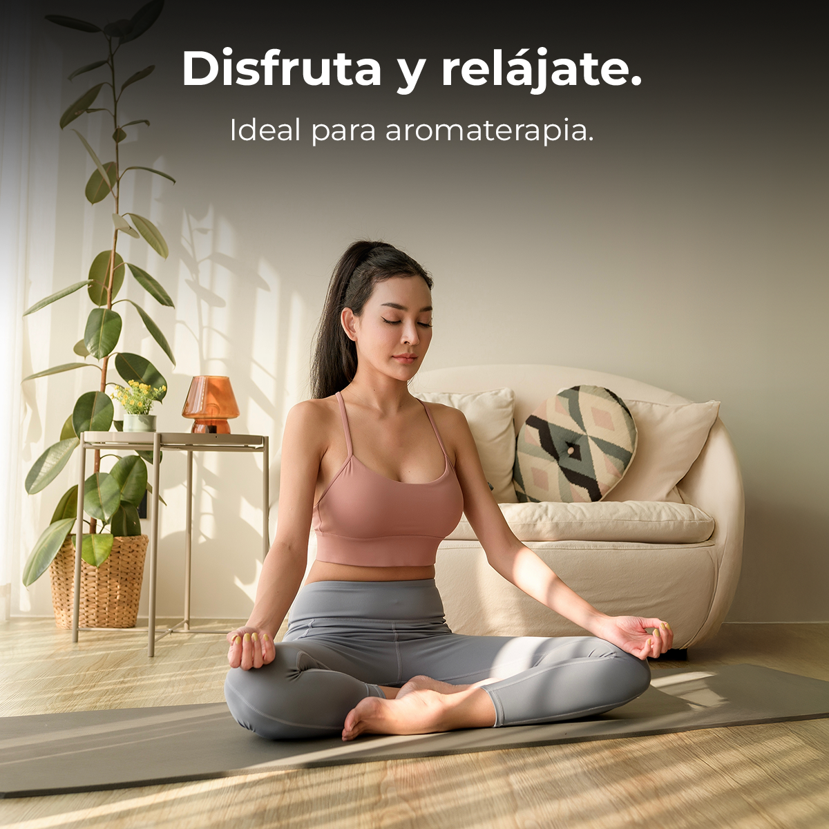 Una mujer en ropa deportiva medita en una esterilla de yoga en una sala de estar luminosa.