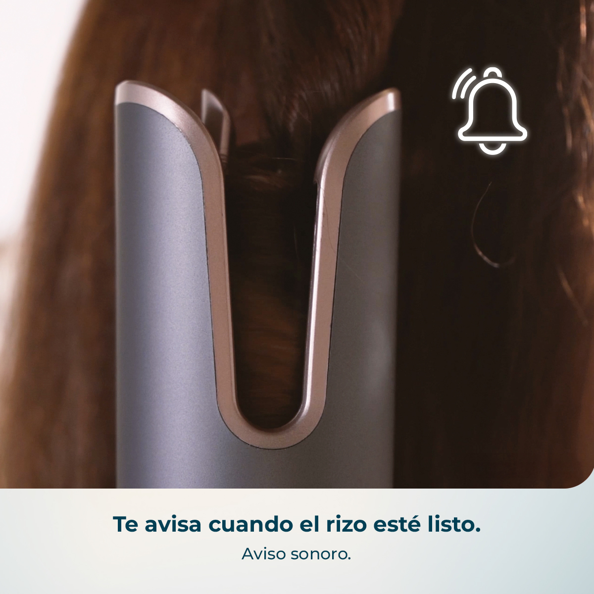 Rizador automático gris y oro rosa rizando cabello castaño, con icono de campana y texto en español abajo.