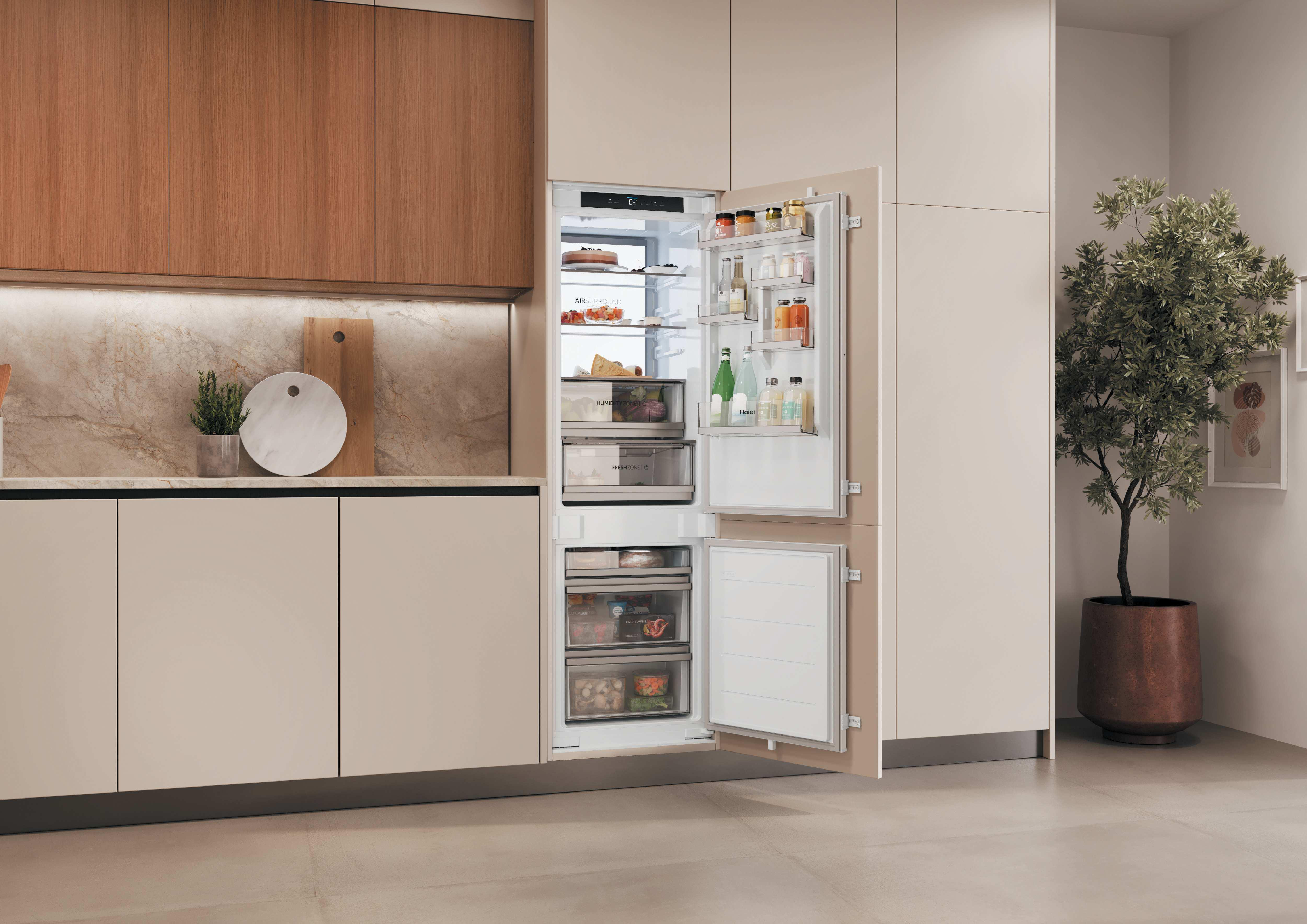 Moderne Küche mit integriertem, geöffnetem Kühlschrank gefüllt mit Lebensmitteln, Holzelementen und Pflanze.