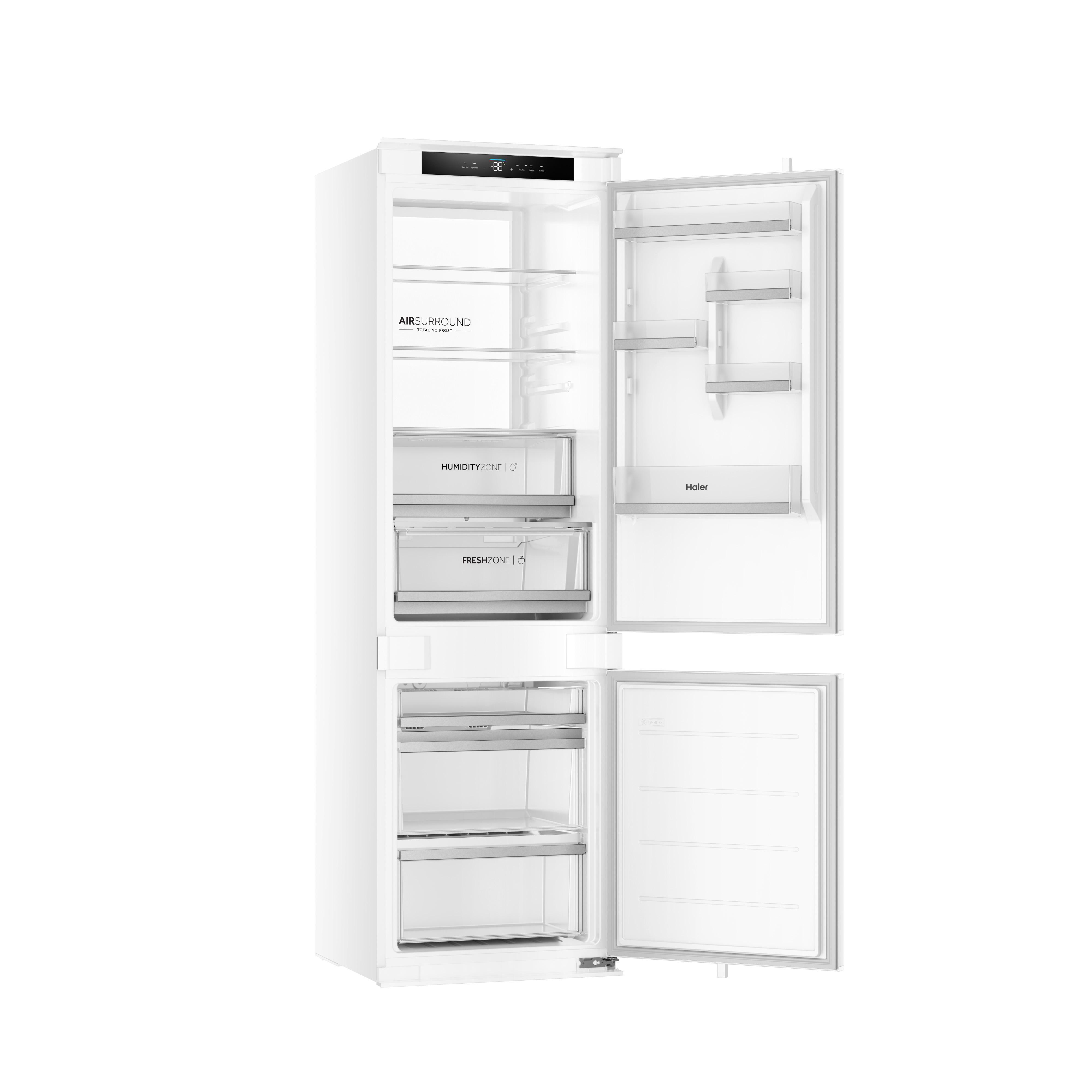 Ein weißer, geöffneter Haier Einbaukühlschrank mit Glasböden und Schubladen vor weißem Hintergrund.