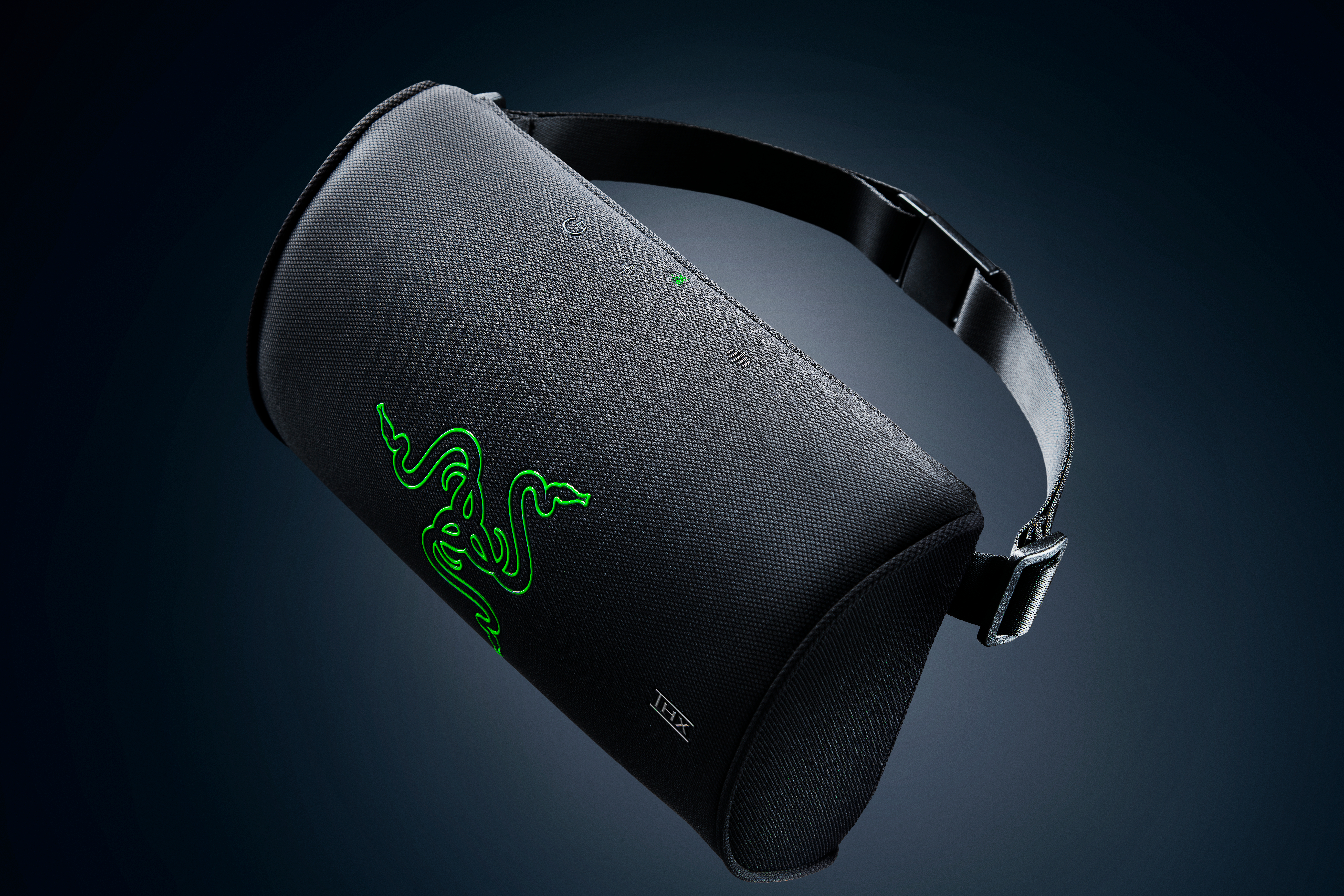 Schwarzer Razer-Nackenkissen-Lautsprecher mit grünem Logo und Stoffband vor dunklem Hintergrund.