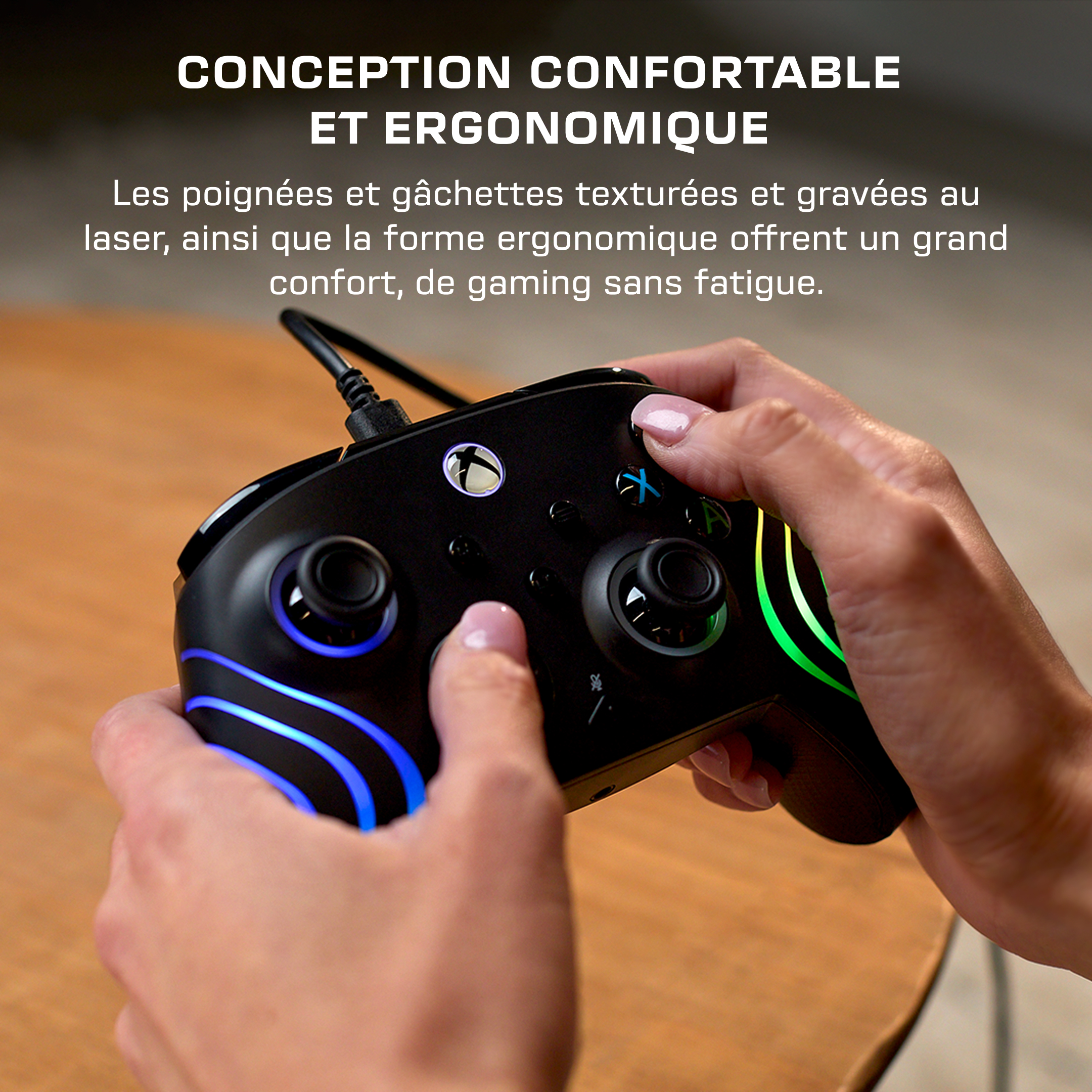 Mains tenant une manette de jeu noire avec un éclairage LED bleu et vert.