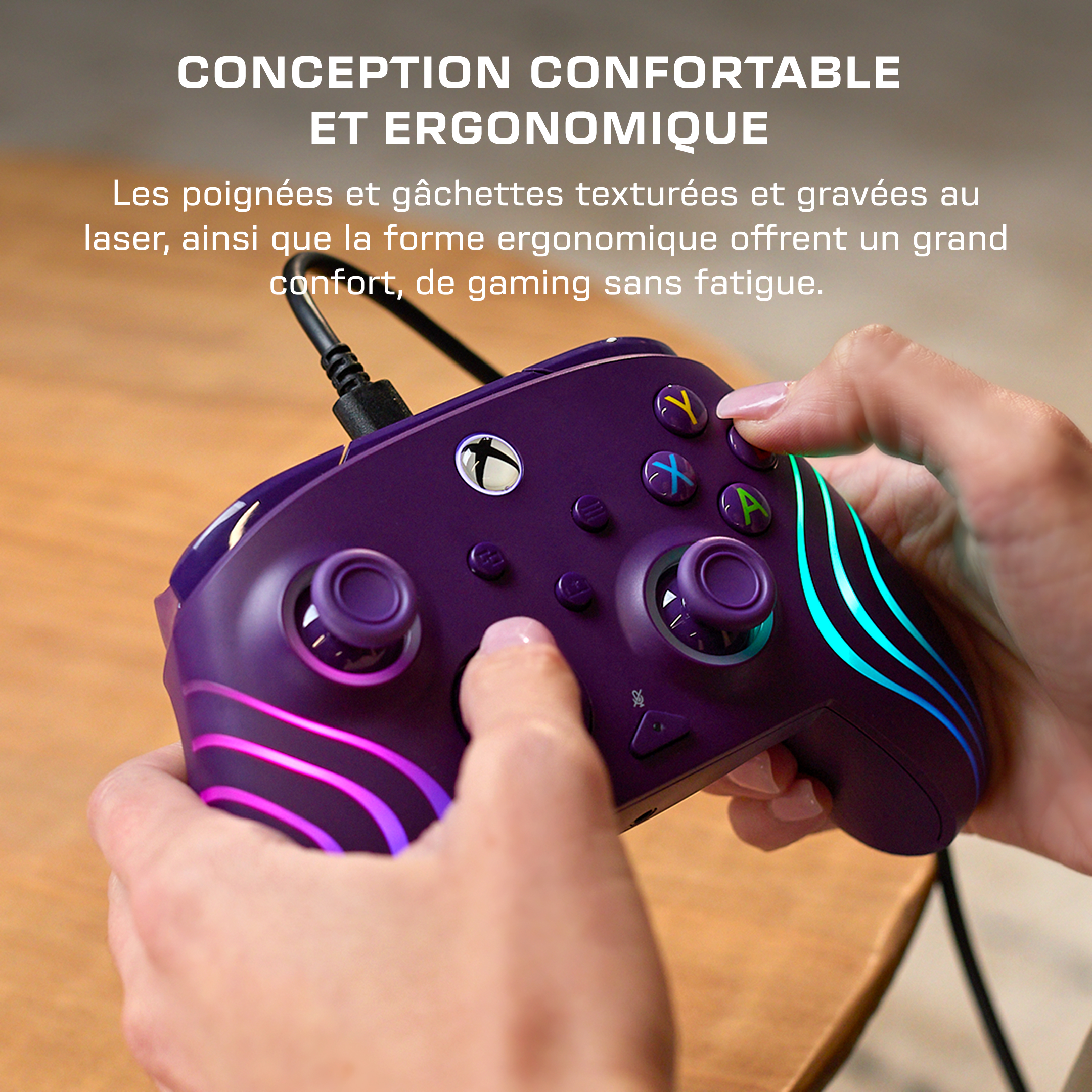 Une personne tient une manette Xbox violette avec des bandes LED cyan et rose lumineuses.