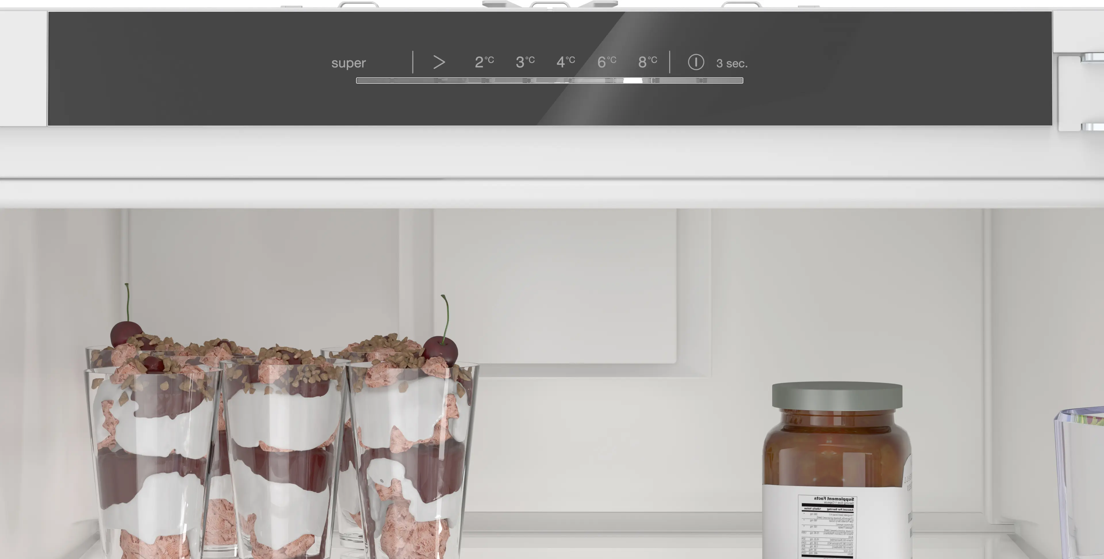 Refrigerador blanco abierto con vasos de postre a la izquierda y un frasco a la derecha, más controles.