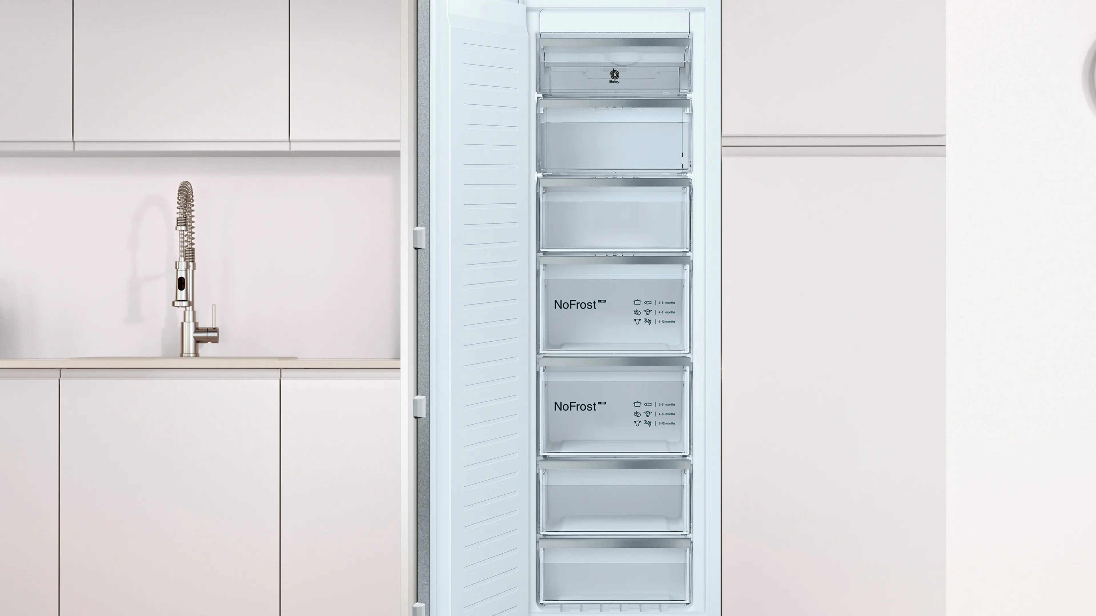 Congelador blanco abierto con cajones NoFrost en una cocina moderna con gabinetes claros y fregadero.