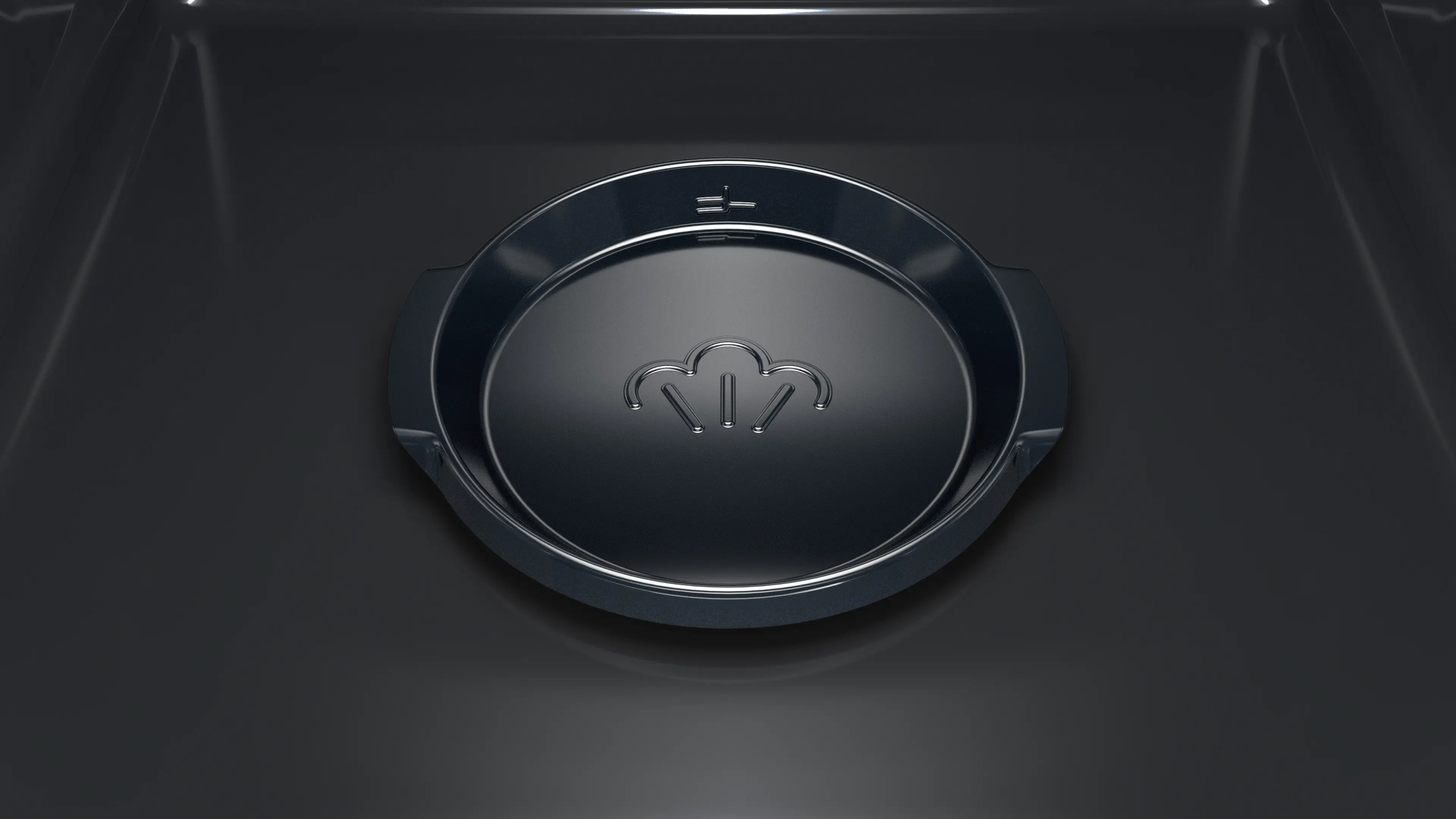 Una bandeja de horno negra con un icono de vapor en el centro descansa dentro de un horno oscuro.
