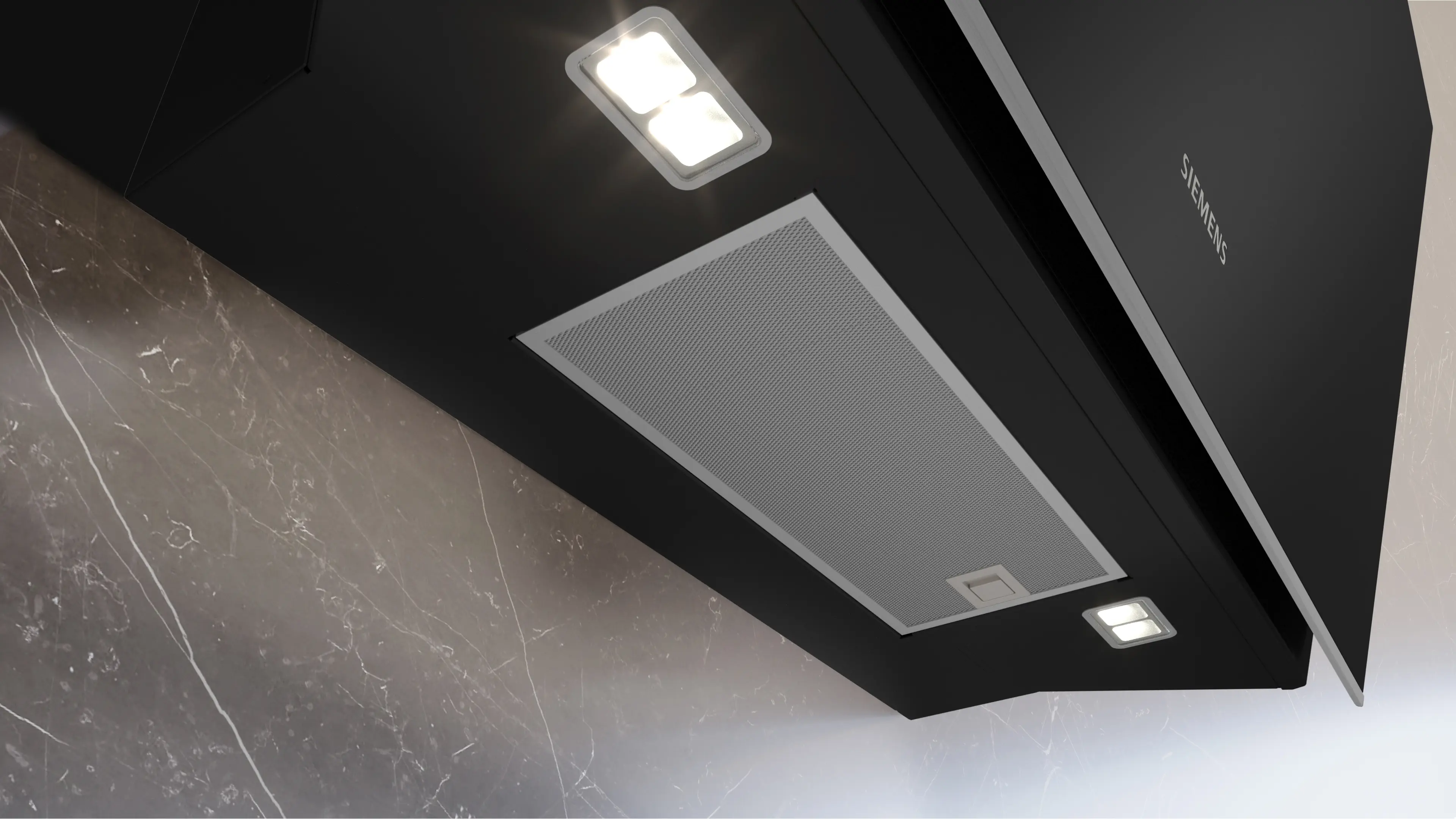 Campana extractora Siemens negra con filtro de metal y luces LED brillantes en una pared de mármol gris.