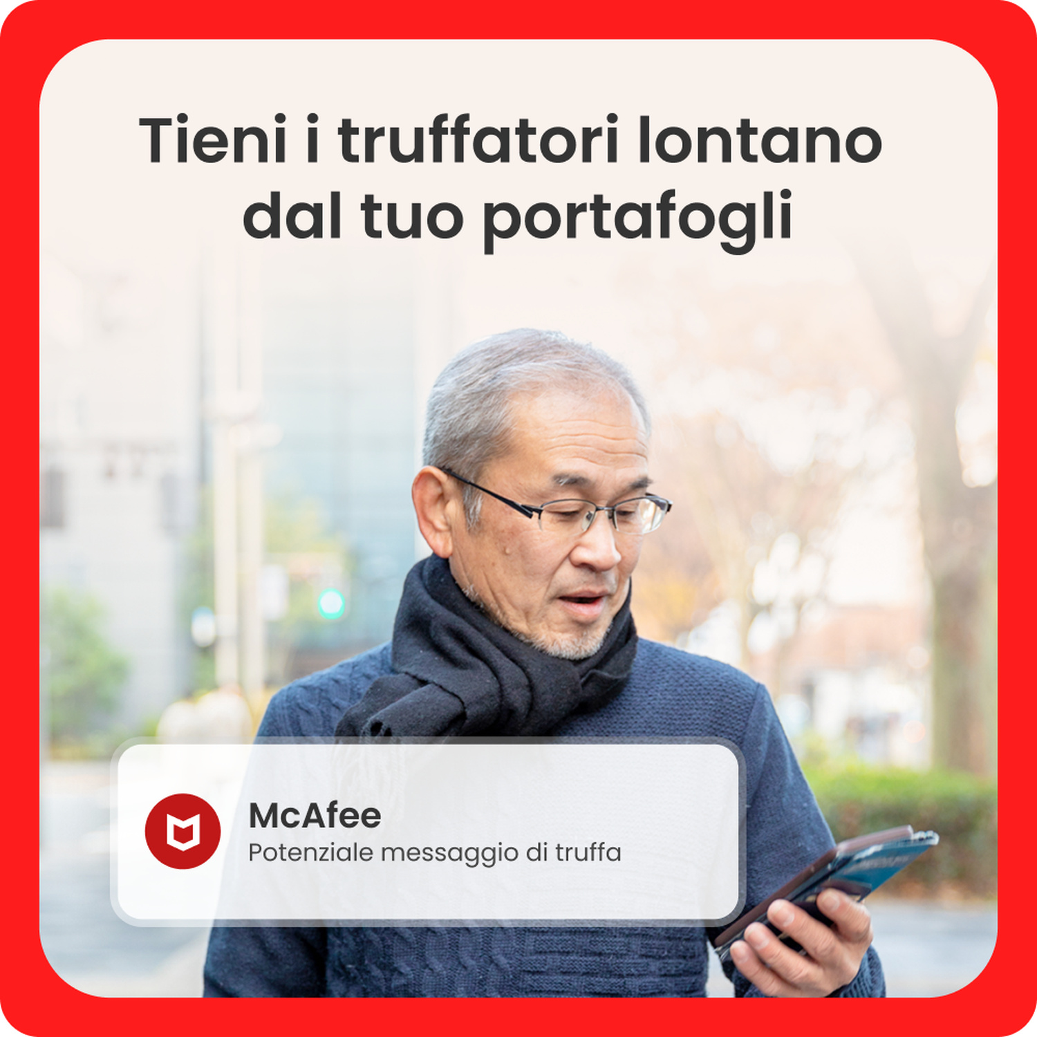 Anziano con maglione blu e sciarpa guarda preoccupato il suo smartphone all'aperto.