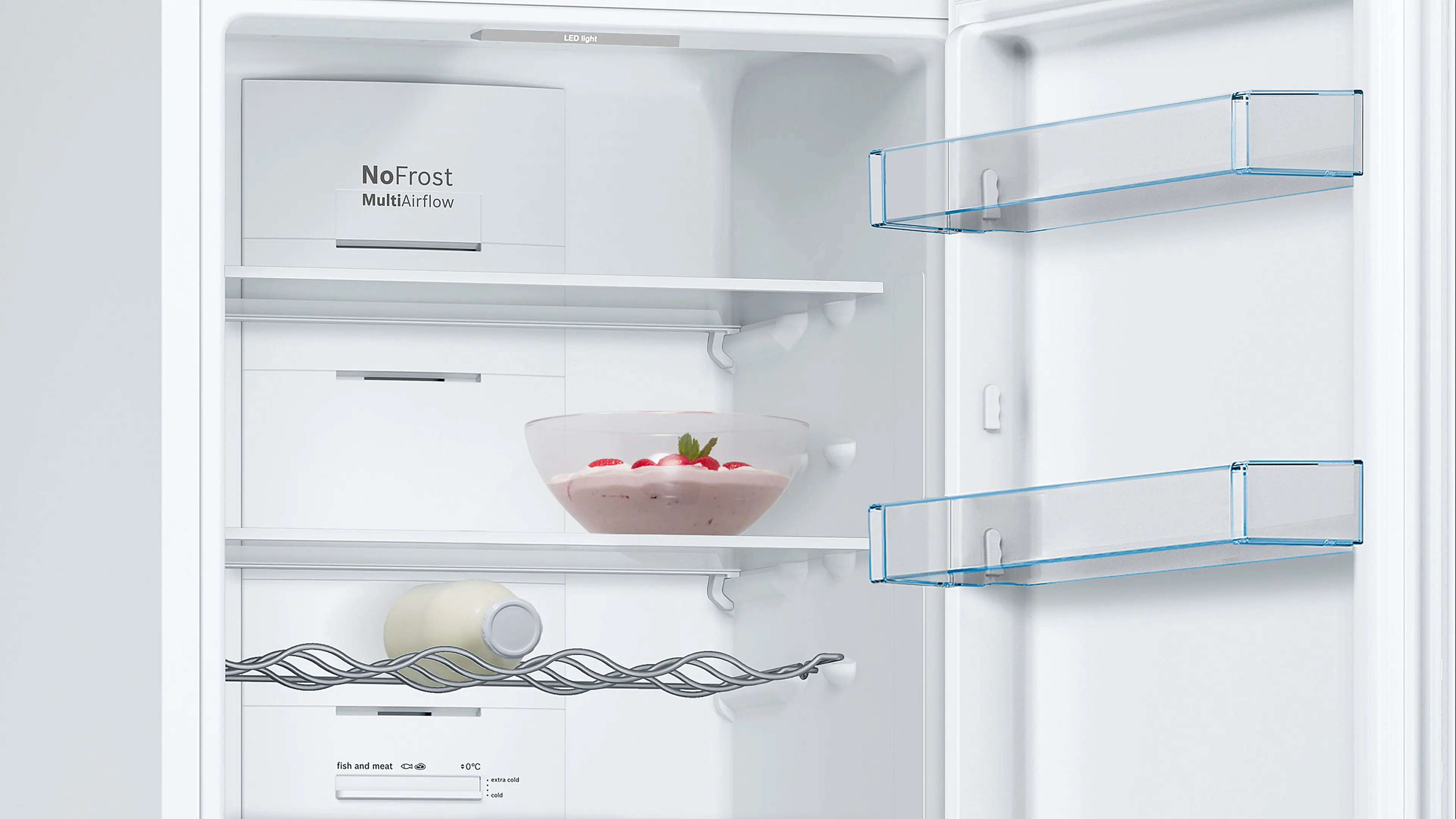 Interior de un refrigerador blanco abierto con estantes de cristal, botellero y un bol con postre.