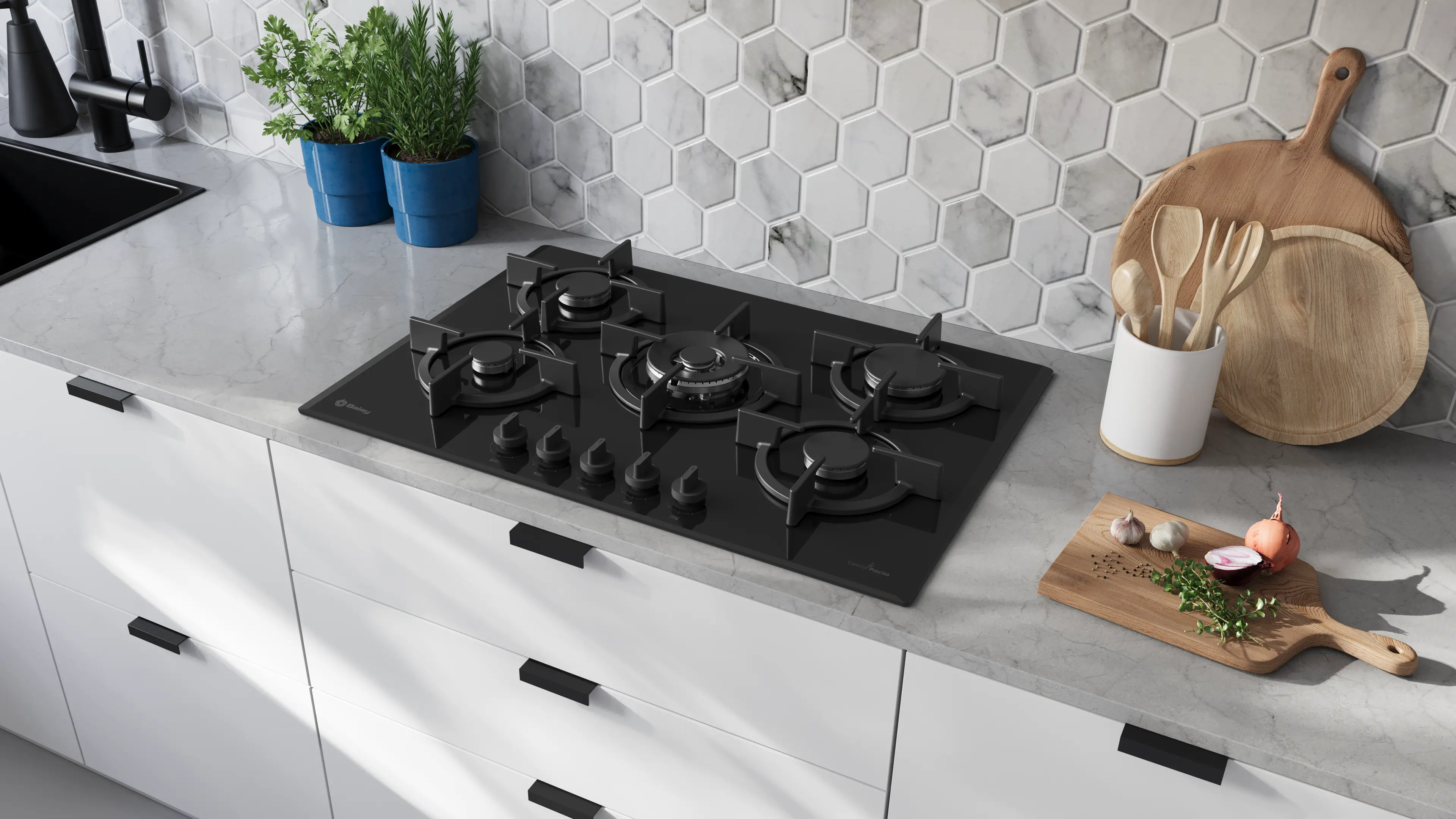 Cocina moderna con encimera de gas negra, encimera blanca, tablas de madera y hierbas ante una pared de mármol.